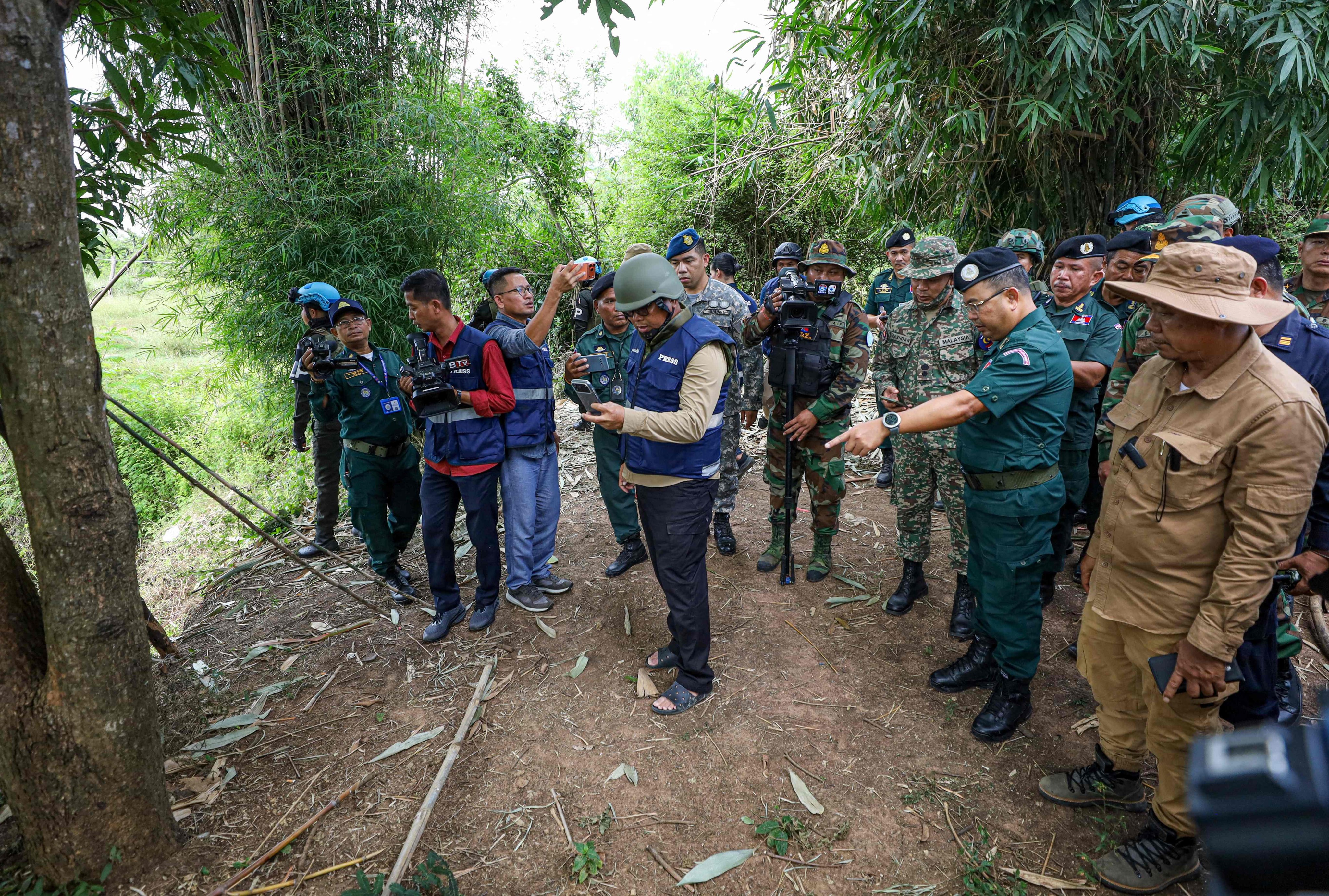 A delegation from the Asean Observer Team visits an area where a civilian was killed a day earlier along the Cambodia-Thailand border in Banteay Meanchey province. Photo: AFP /Agence Kampuchea Press
