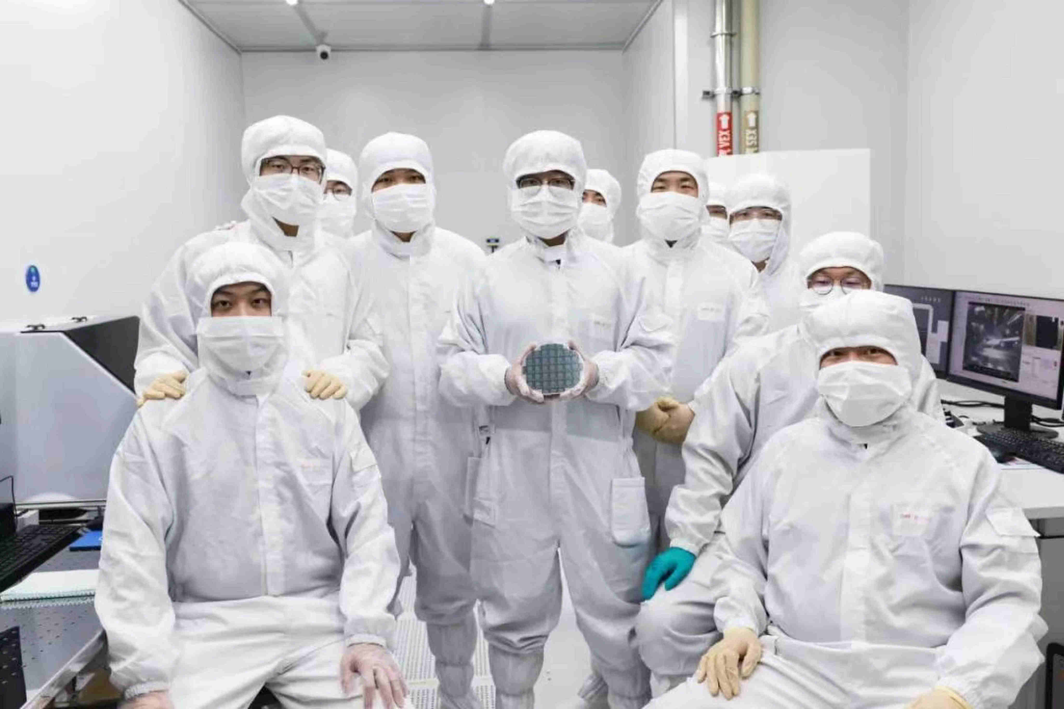Researchers at CHIPX pose for a photo with their high-performance 6-inch thin-film lithium niobate chip, an advance that is poised to accelerate progress in AI and quantum computing.  Photo: Handout