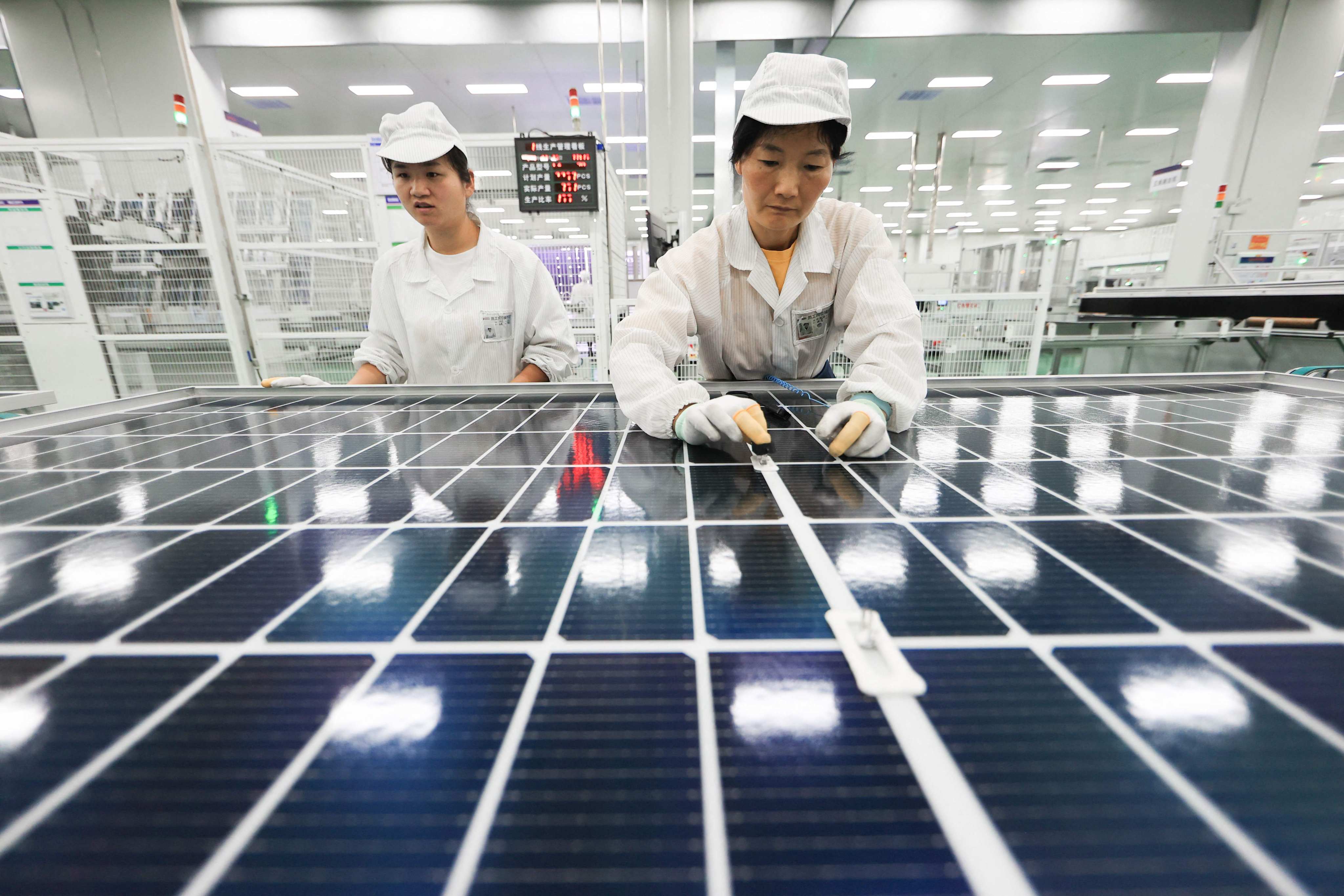 Employees help to produce photovoltaic cell modules at a factory in Lianyungang, Jiangsu province, in September. Photo: AFP