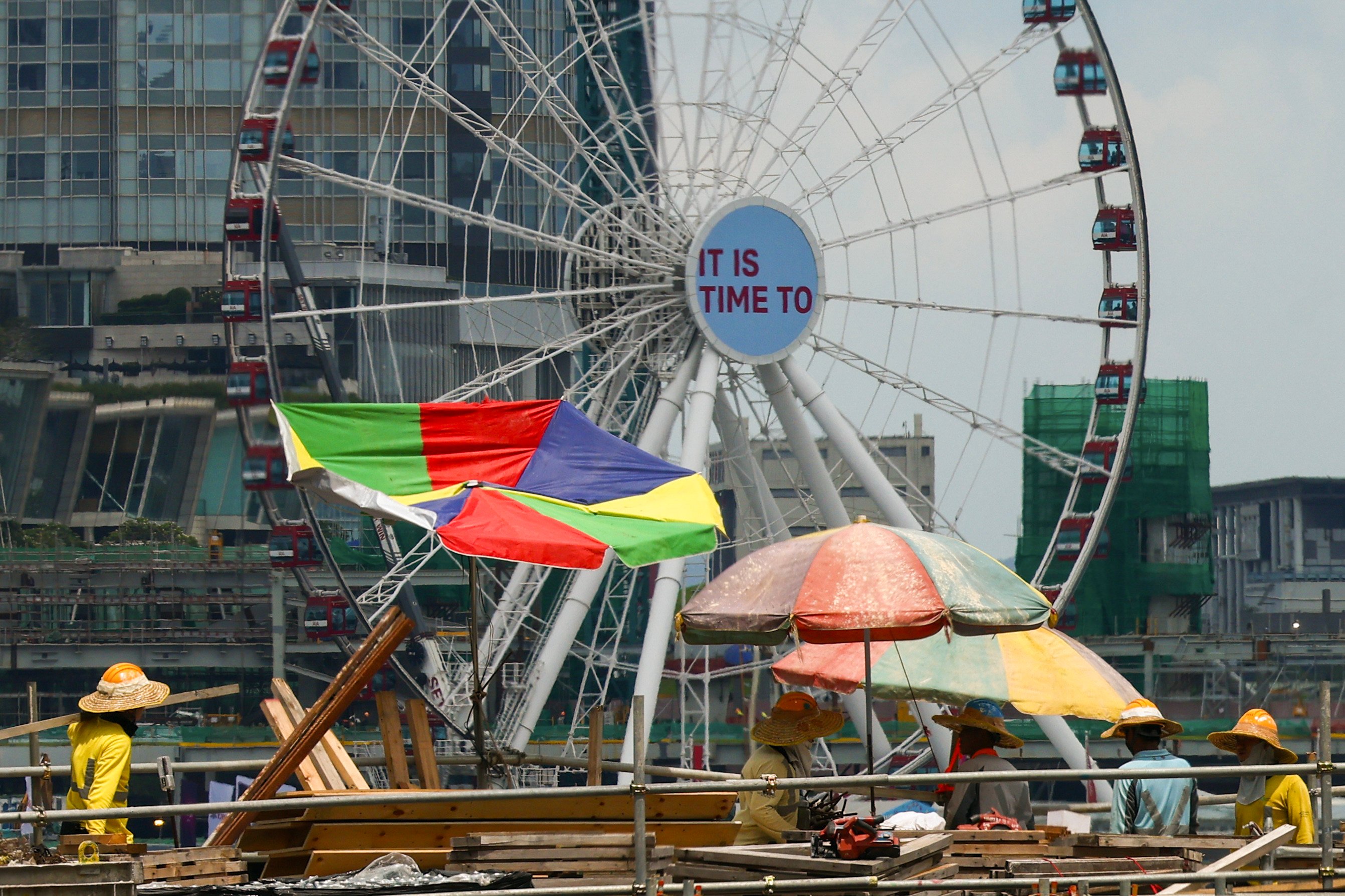 Construction workers put up large umbrellas in Wan Chai on May 23, when a very hot weather warning was issued. Hong Kong has suffered 50 to 60 hot nights (over 28 degrees) every year since 2020, compared with around 20 a year a decade earlier. Photo: Dickson Lee