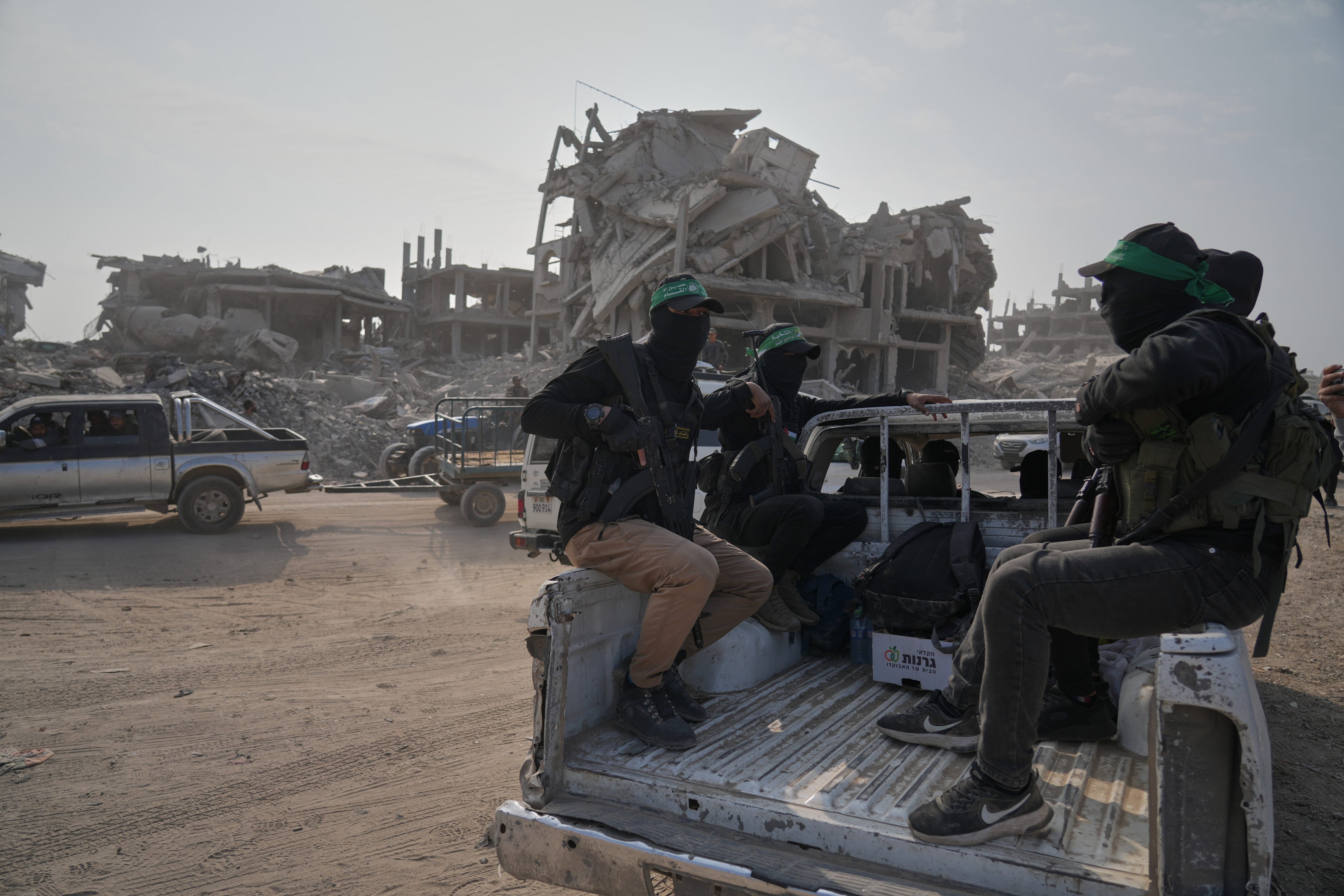 Hamas militants accompanied by members of the International Committee of the Red Cross head to east of Gaza City to search for the bodies of hostages on Thursday. Photo: AP