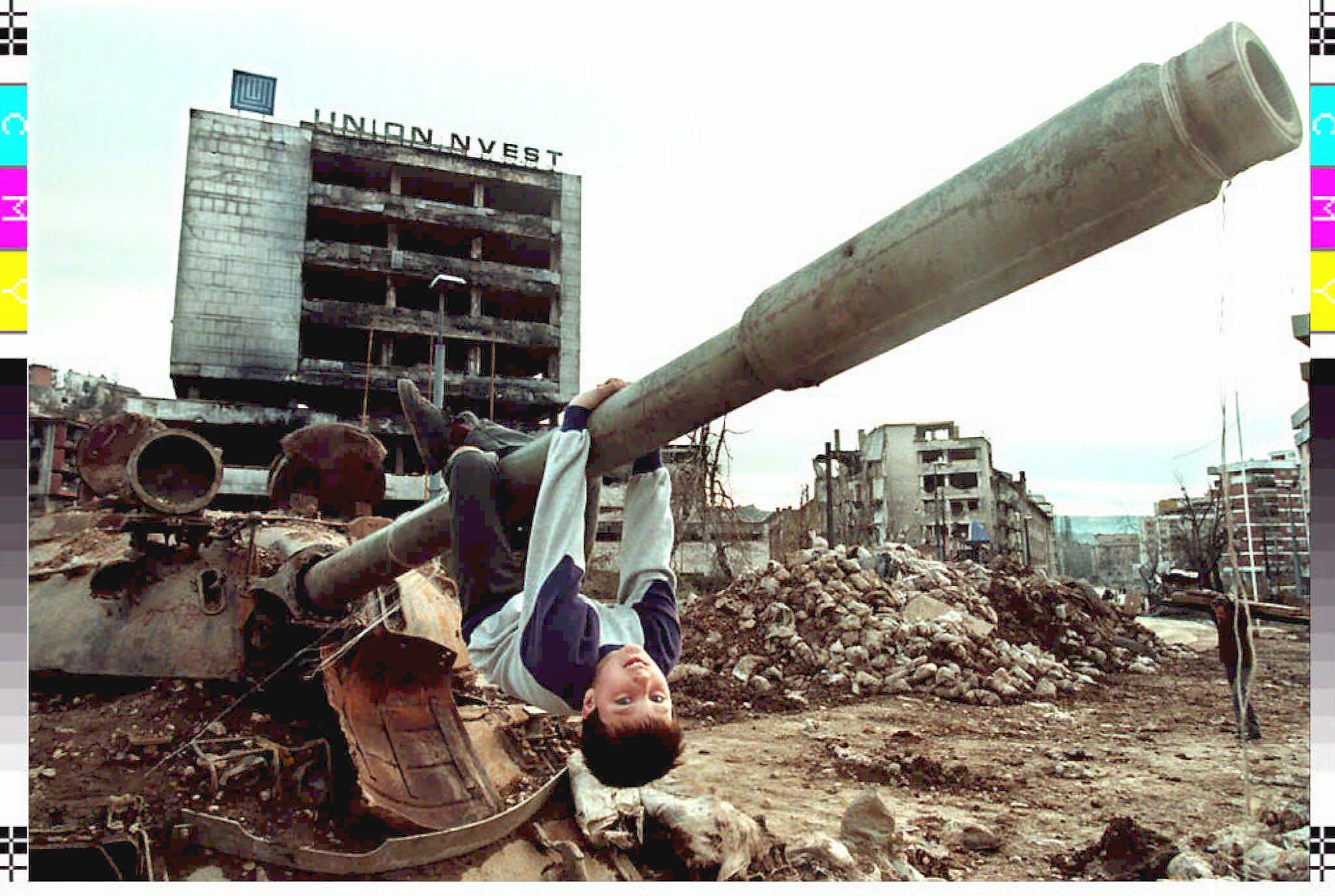 A boy hangs on the barrel of a destroyed Russian-made T-54 tank while playing in Sarajevo in April 1996. Photo: AFP