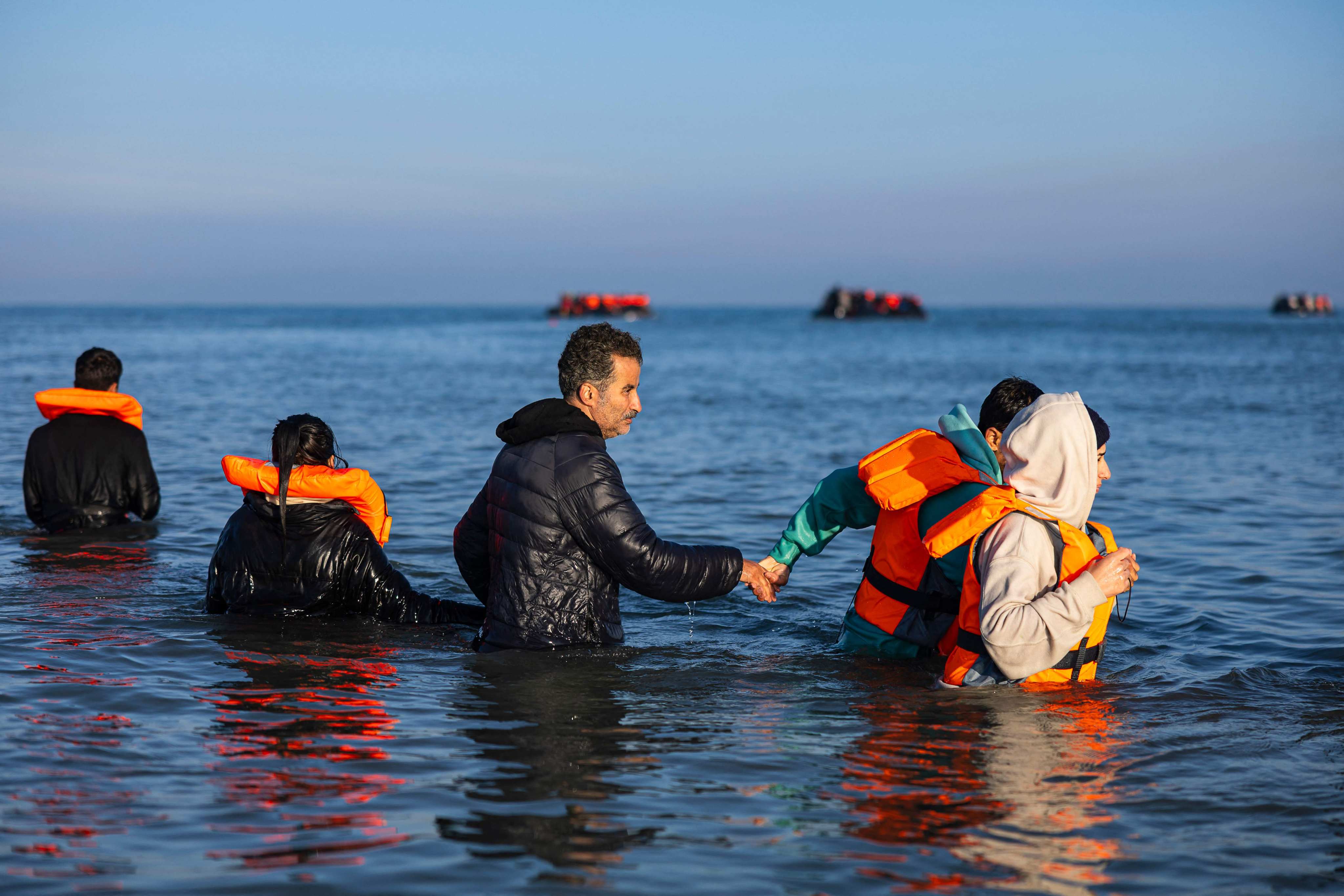 Migrants wade into the sea to try to board smugglers’ boats and cross the English Channel from France into Britain in September. Photo: AFP