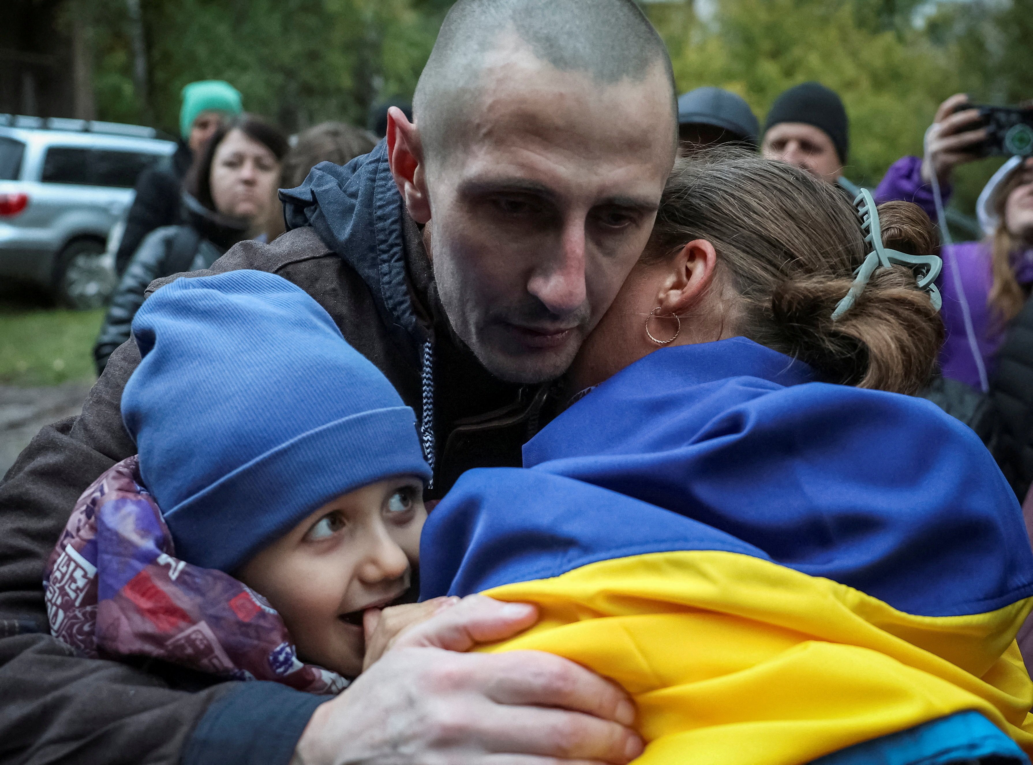 A freed Ukrainian prisoner of war mbraces his relatives after a swap of POWs, amid Russia’s attack on Ukraine, in an undisclosed location in Ukraine on October 2. Photo: Reuters