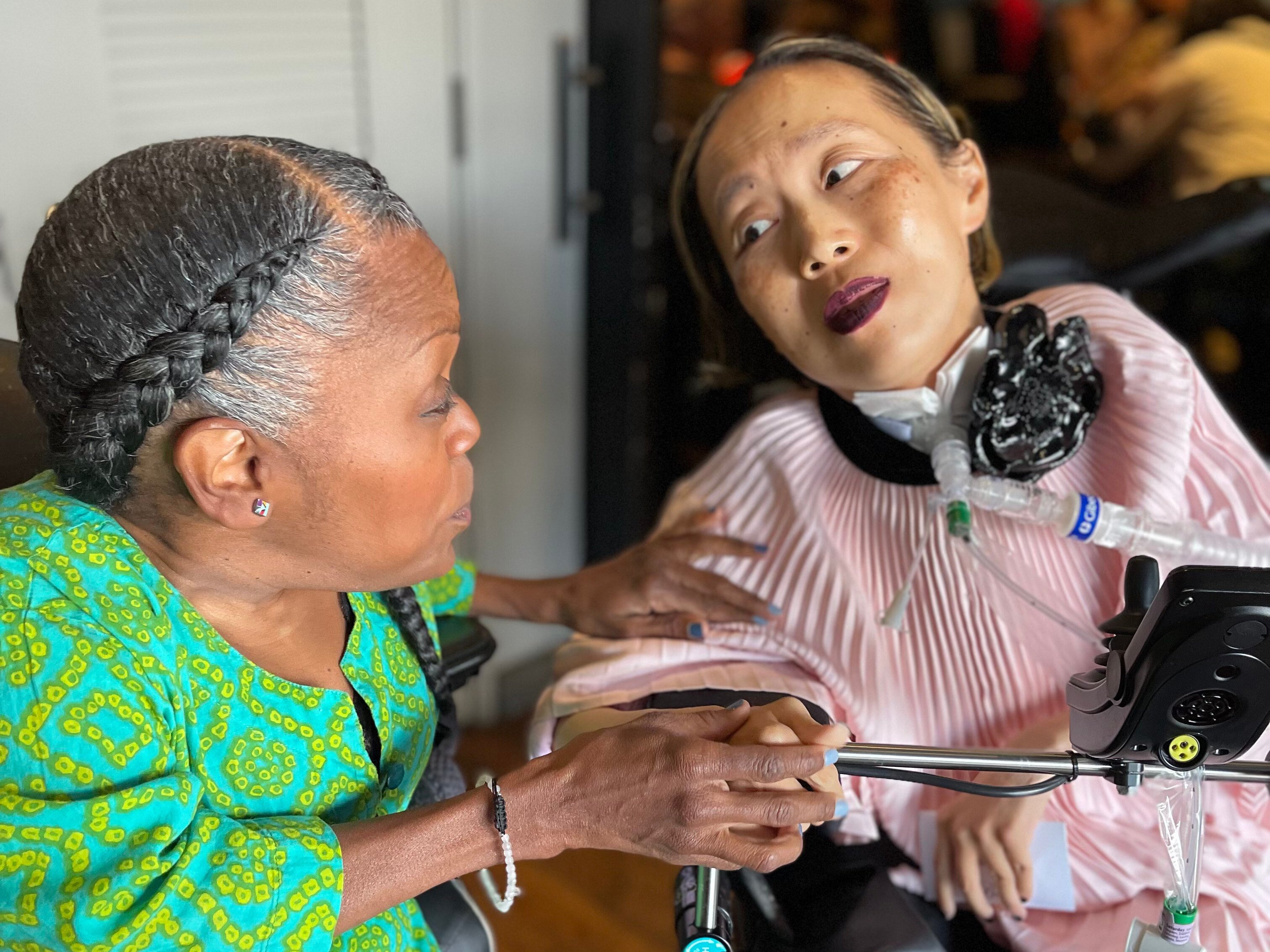 Alice Wong (right) speaks with Yomi Young during the activist’s 50th birthday party in San Francisco in March. Photo: Sandy Ho via AP