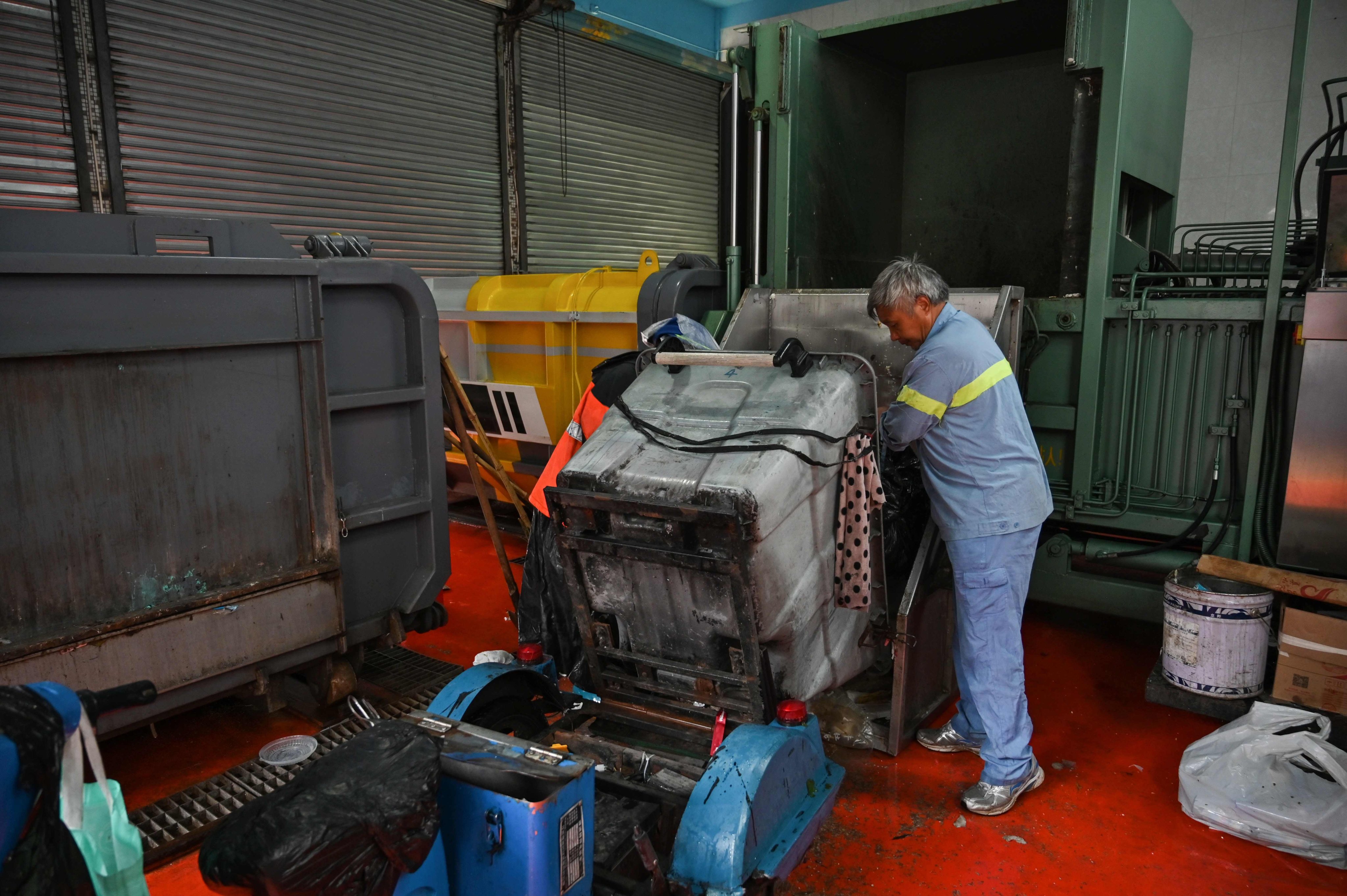 A worker deposits waste into a container at a garbage-transfer station in China. Photo: AFP