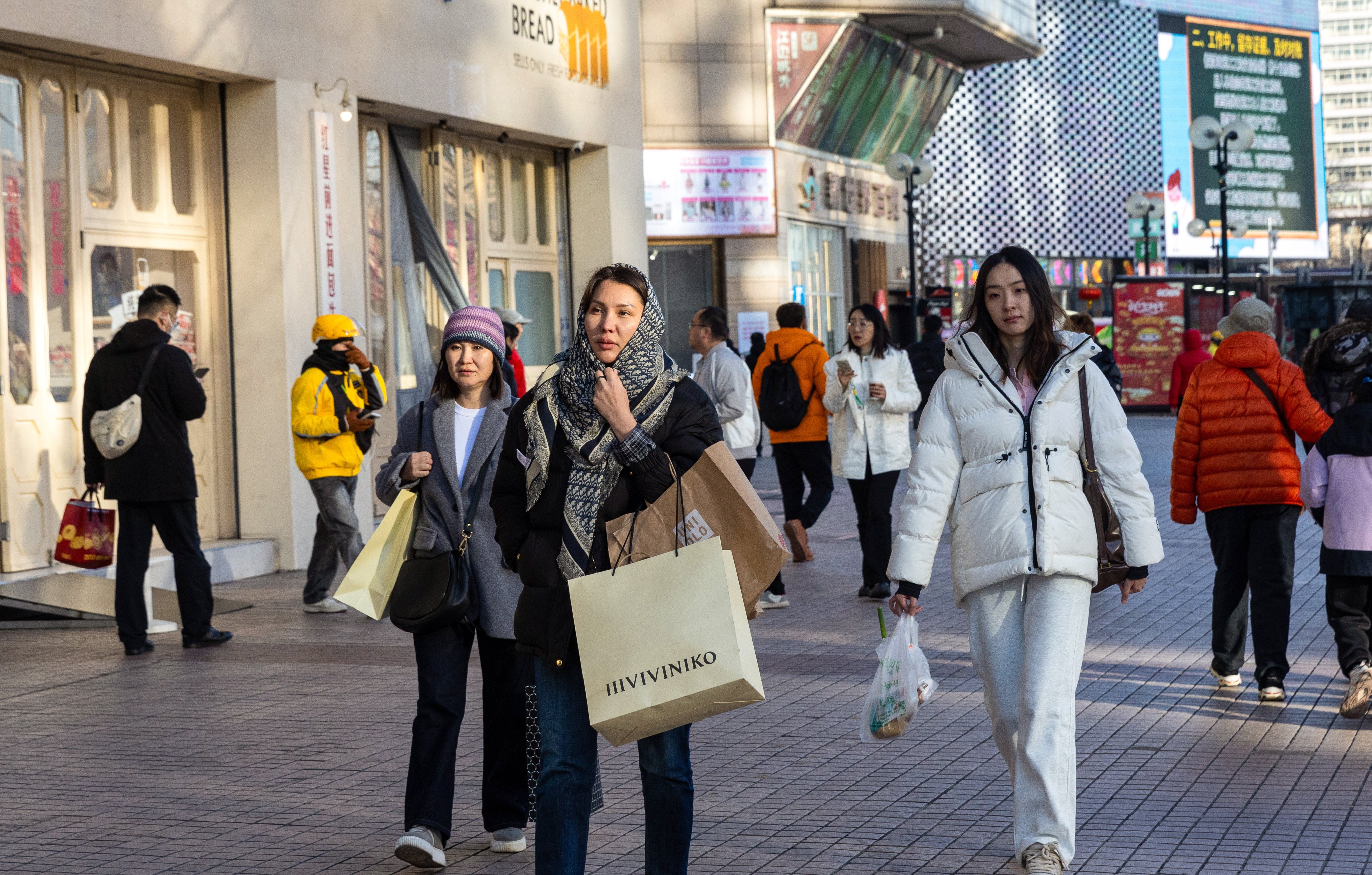 Shoppers walk the streets in Beijing. China projects its middle-income population will reach 800 million within the next 10 years. Photo: EPA-EFE