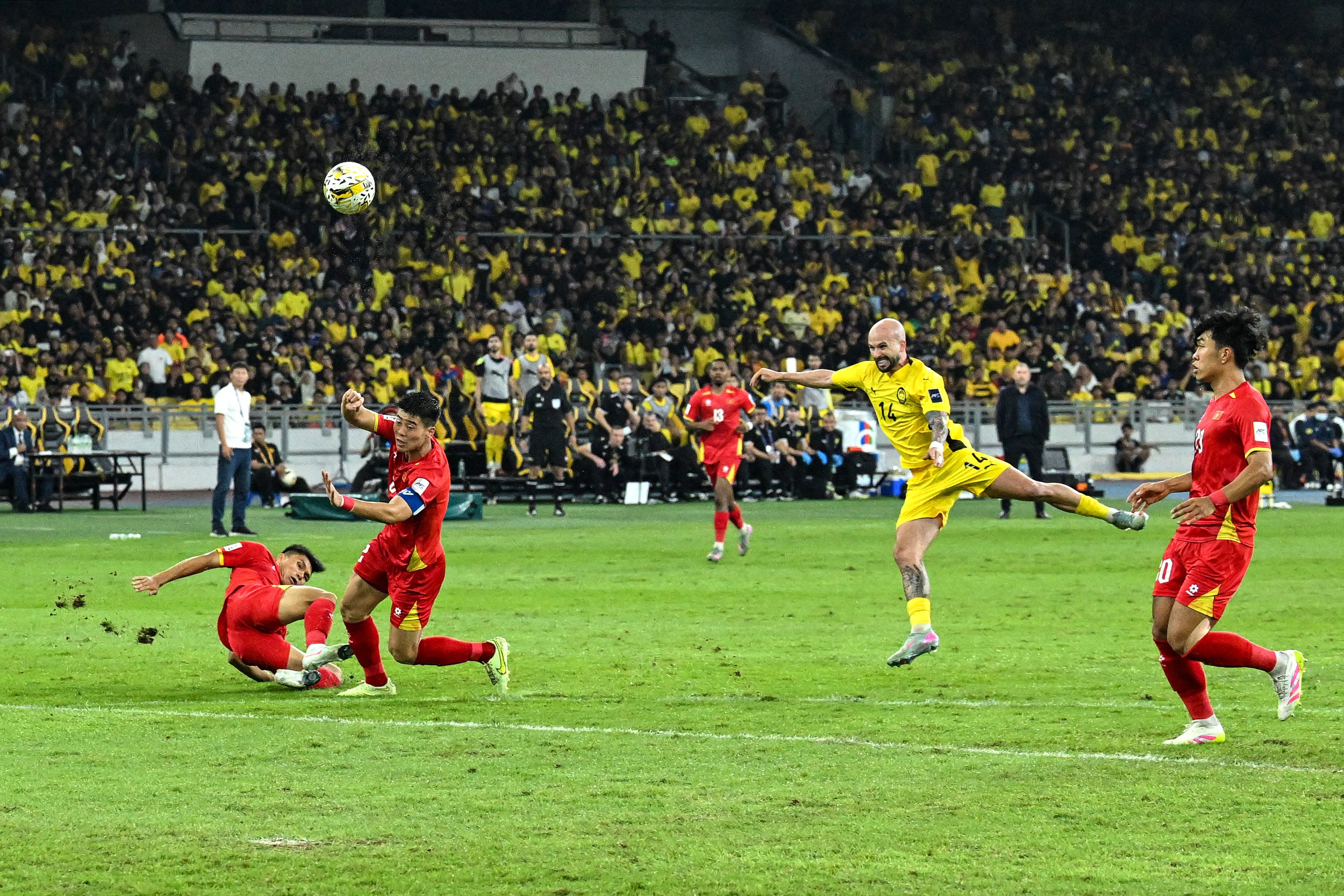 Joao Vitor Figueiredo (in yellow) scores a goal for Malaysia during the AFC Asian Cup qualifier against  Vietnam on June 10. Photo: AFP