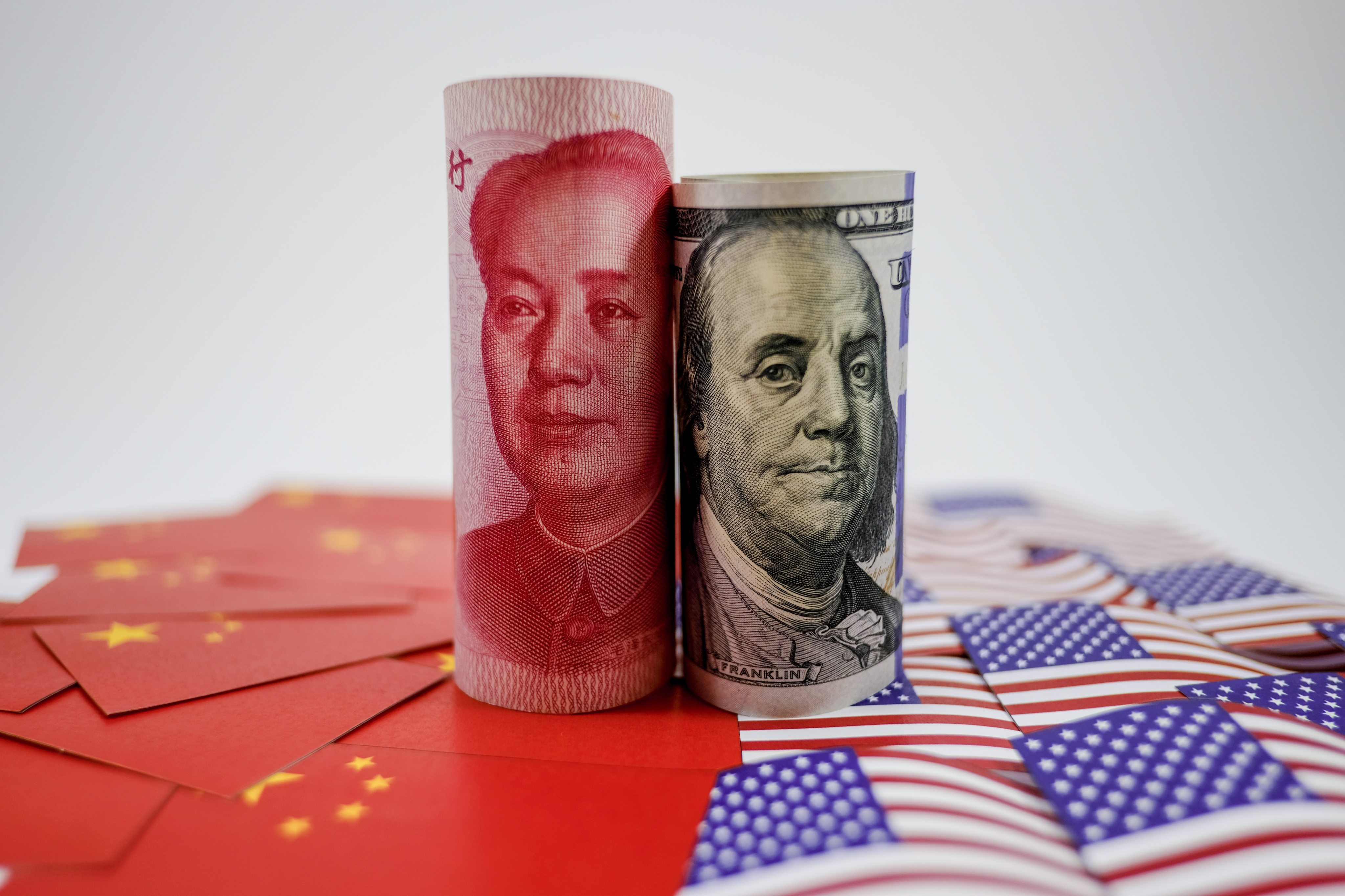 Yuan banknote on Chinese flags and US dollar banknote on US flags. Photo: Getty Images/iStockphoto