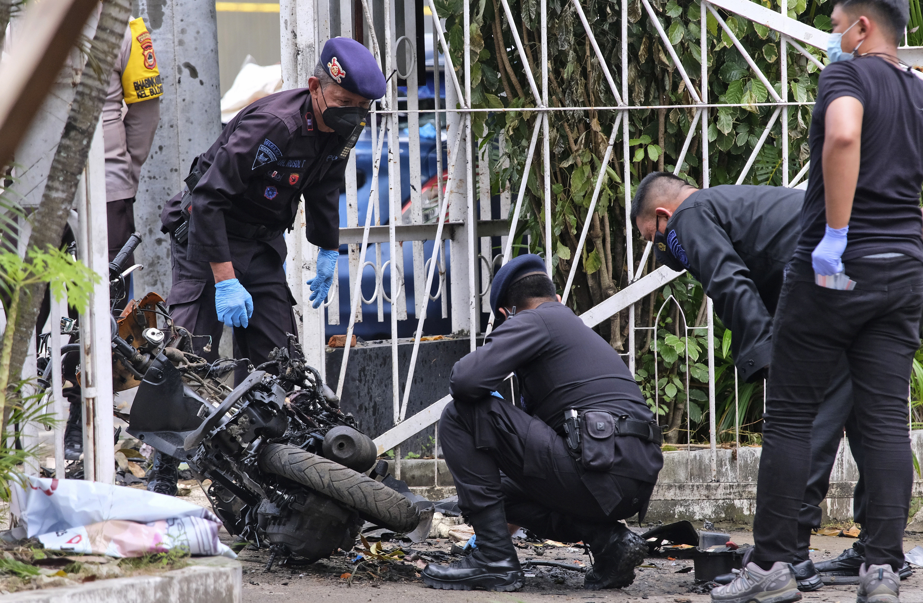 Members of a police bomb squad inspect the wreckage of a motorbike used to carry out a suicide attack in  South Sulawesi, Indonesia, on  March 29, 2021. Photo: AP