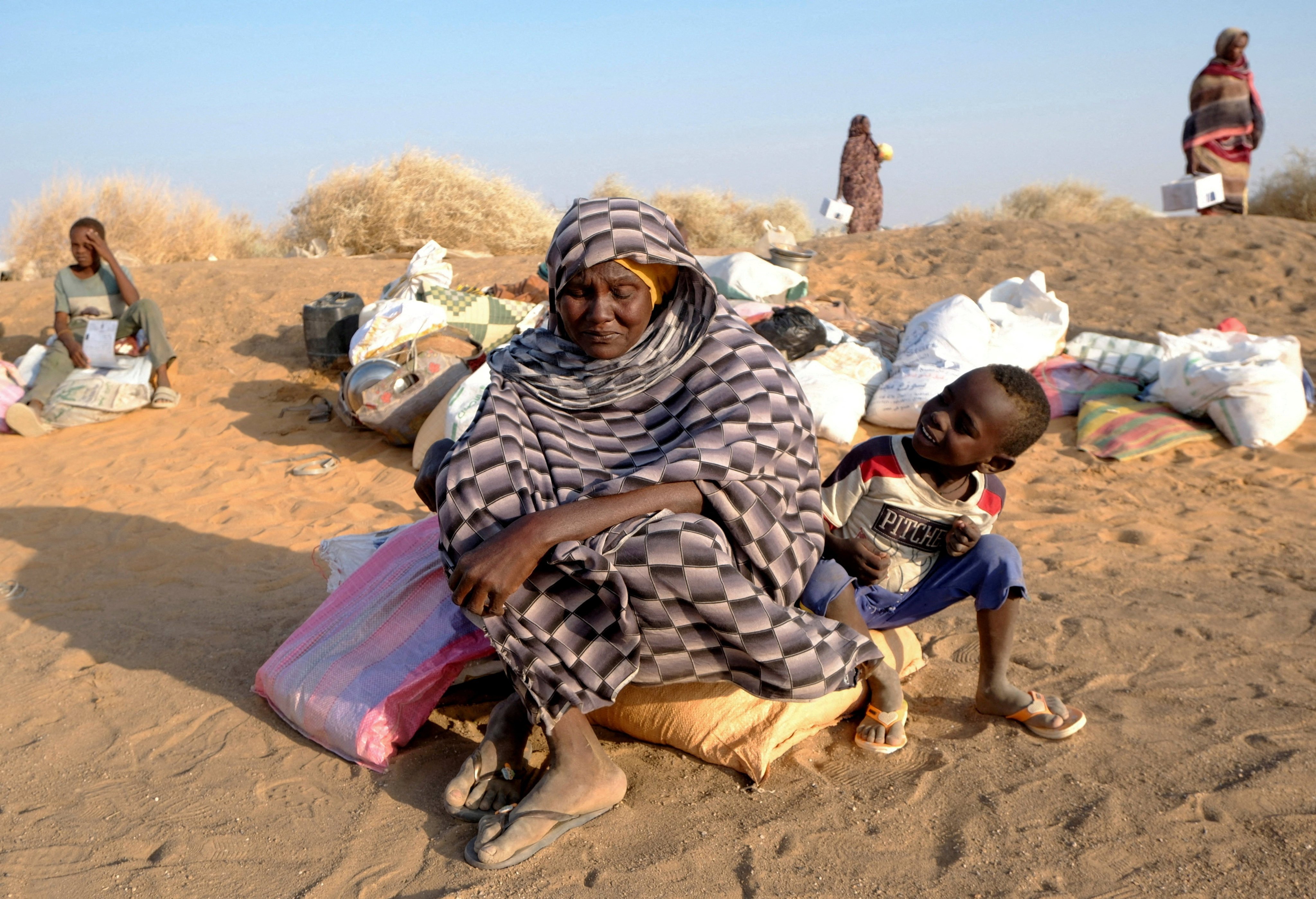 A displaced woman from El Fasher sits with her child as they wait for permission to enter a camp in Al-Dabbah, Sudan, on November 13. Photo: Reuters