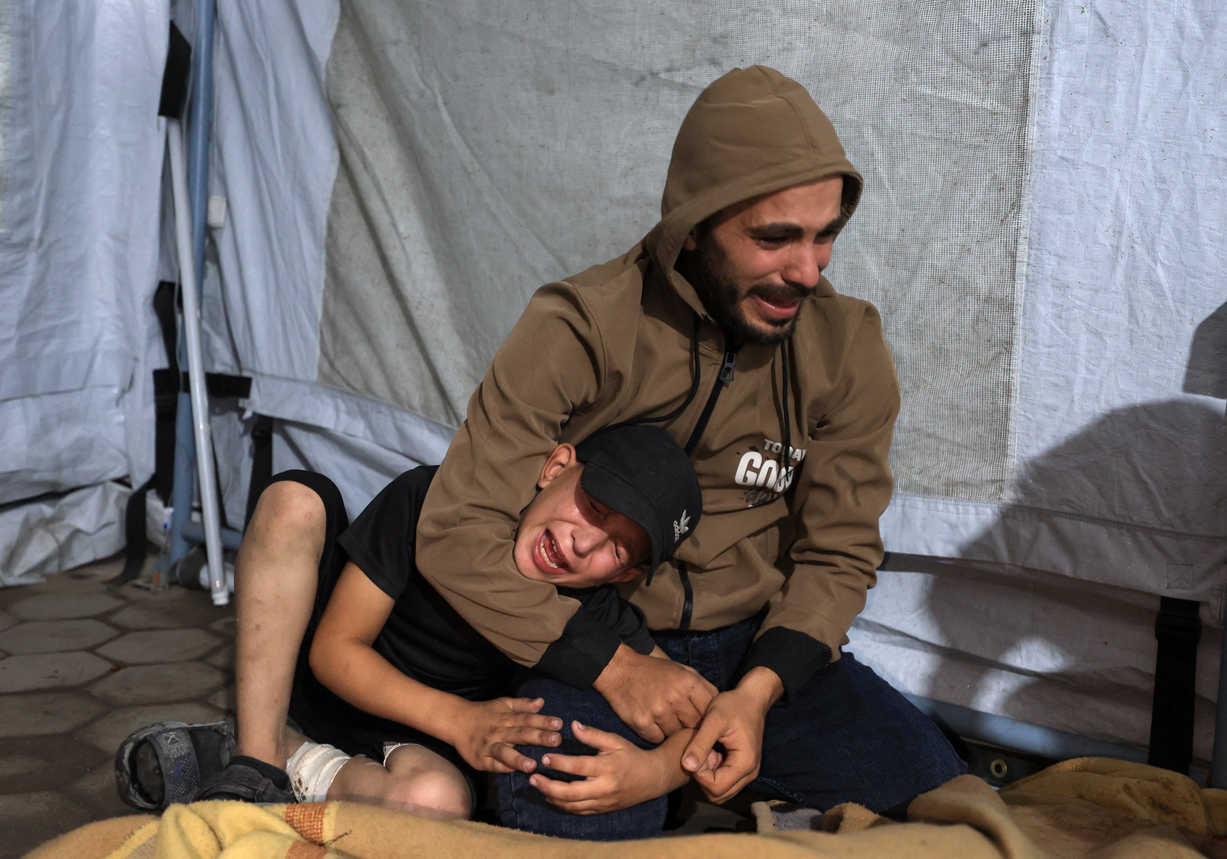 A man and a child mourn at Al-Ahli Arab Hospital in Gaza City on Wednesday, after a deadly Israeli strike. Photo: Reuters