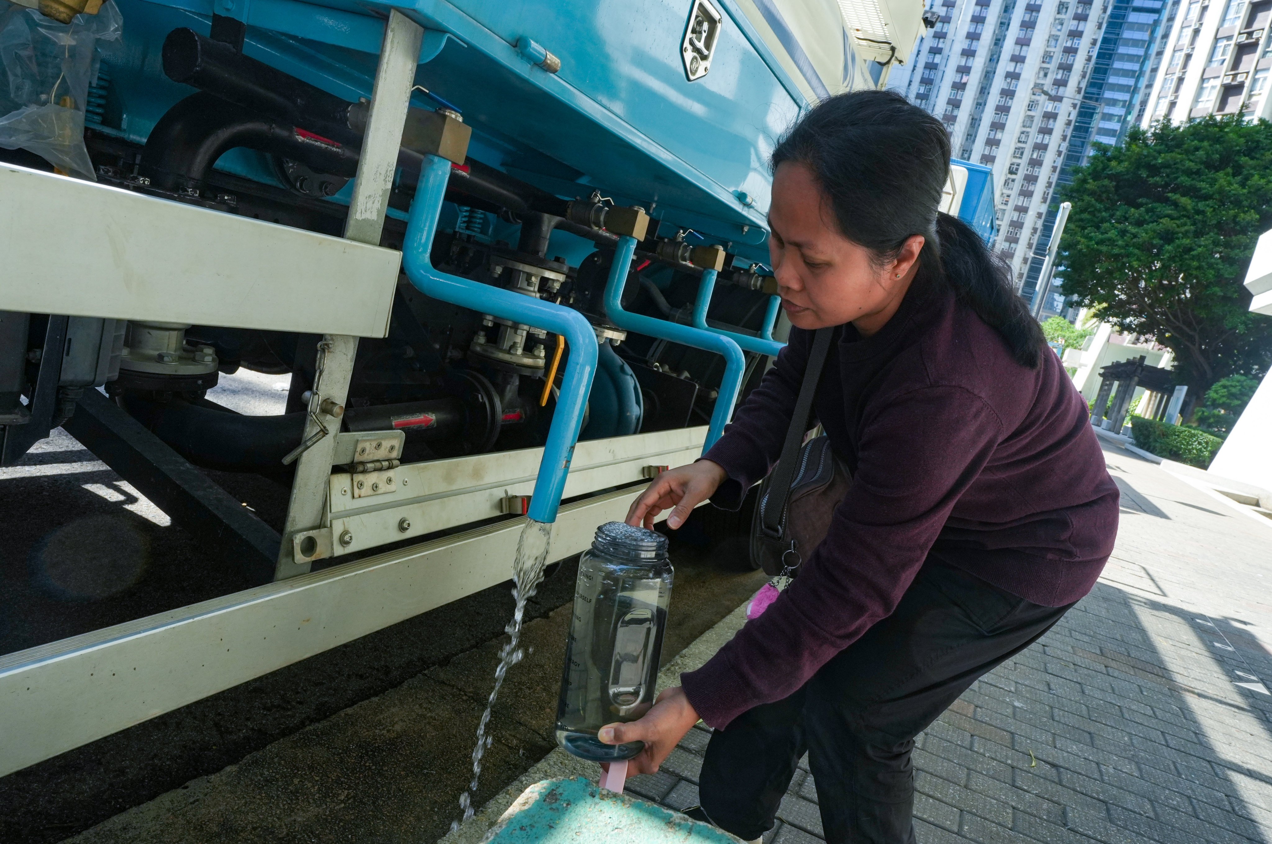 A resident fills up a bottle at a water truck dispatched by the Water Supplies Department to Taikoo Shing on November 17. Photo: Sun Yeung
