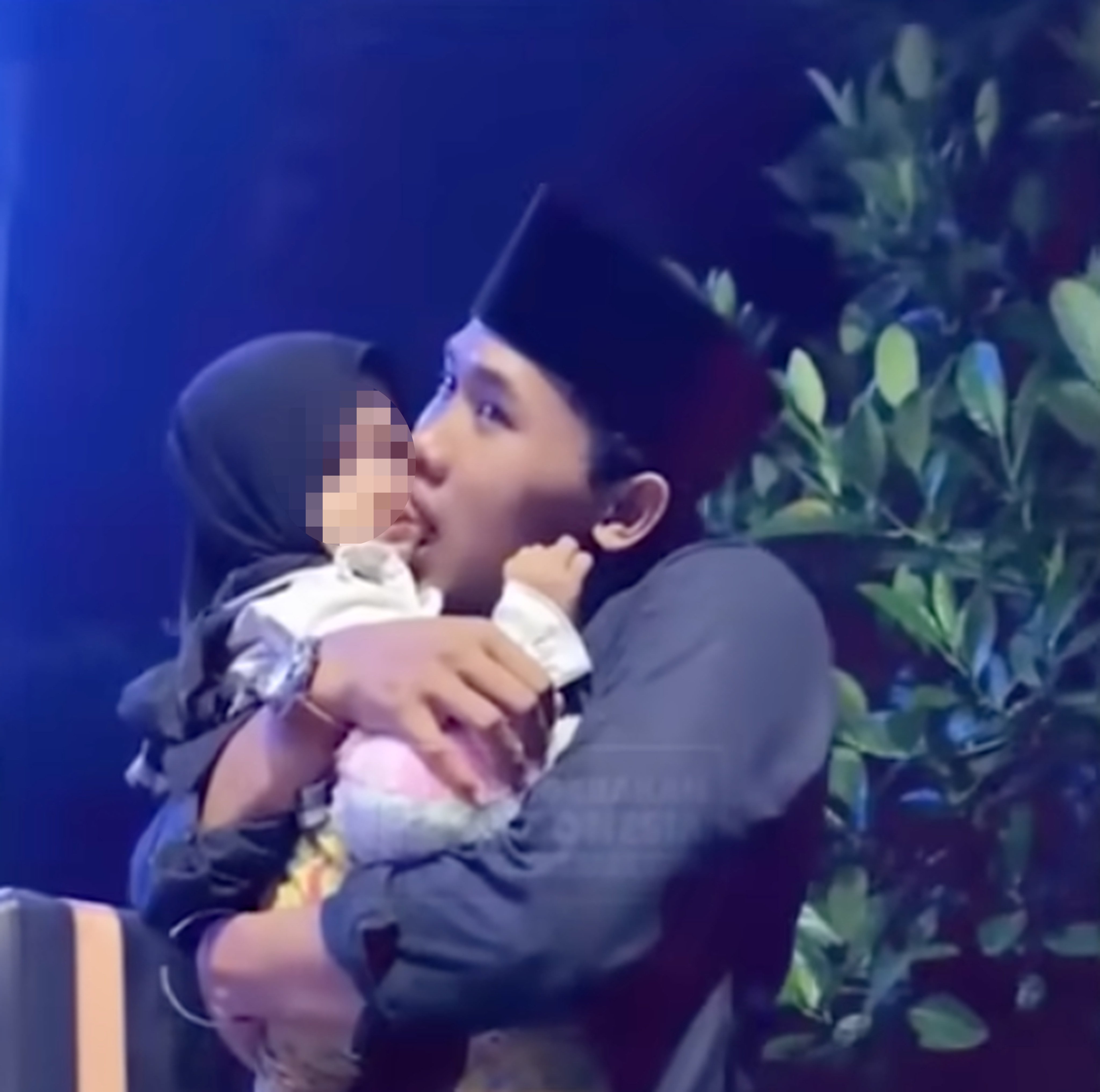 Islamic cleric Mohammad Elham Yahya Al Maliki is seen embracing a young girl and sucking in her cheeks. Other clips show him kissing several children on the cheek. Photo: YouTube/Gerakanpis