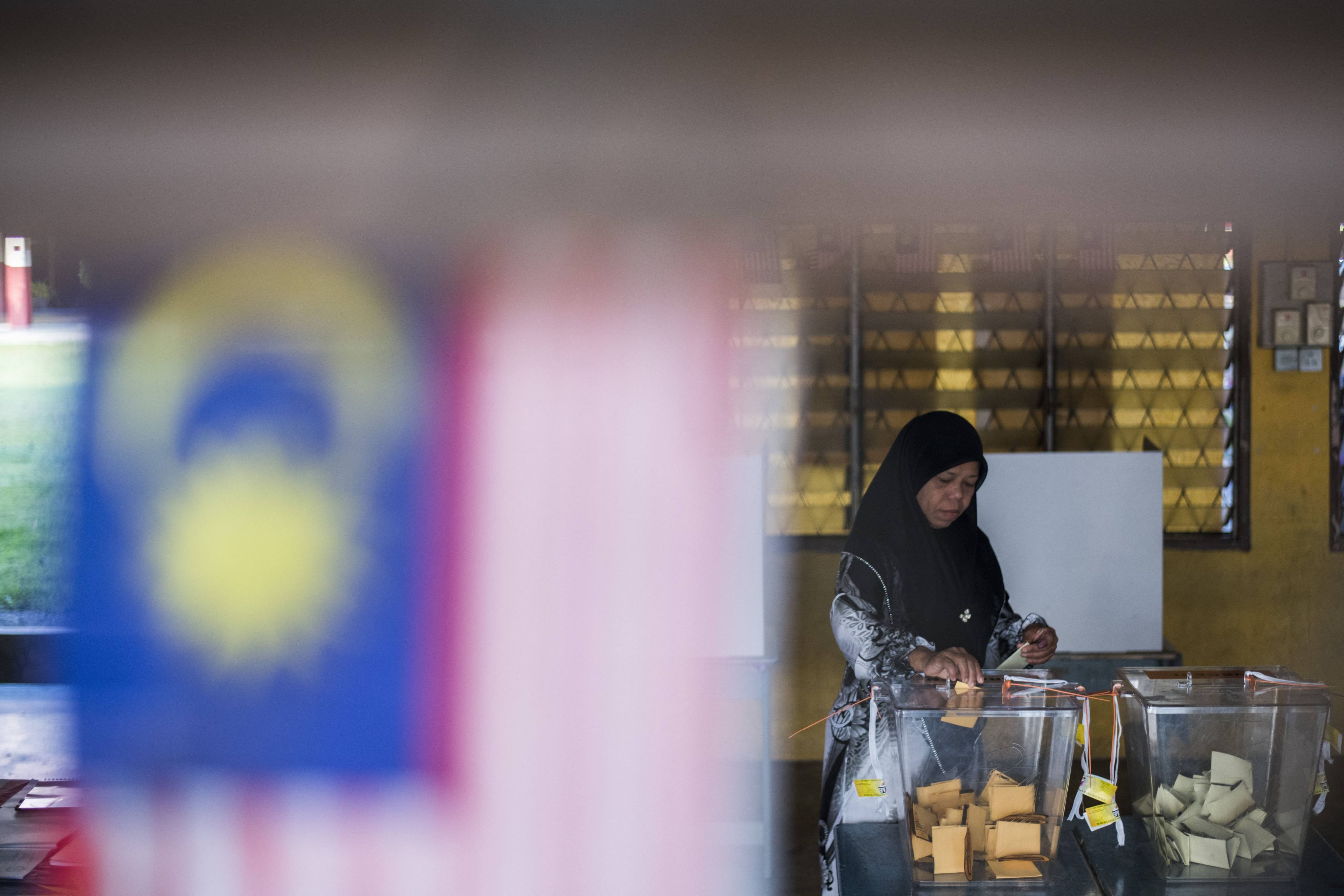 A woman casts her ballot at a polling station during a previous election in Malaysia. Photo: AFP