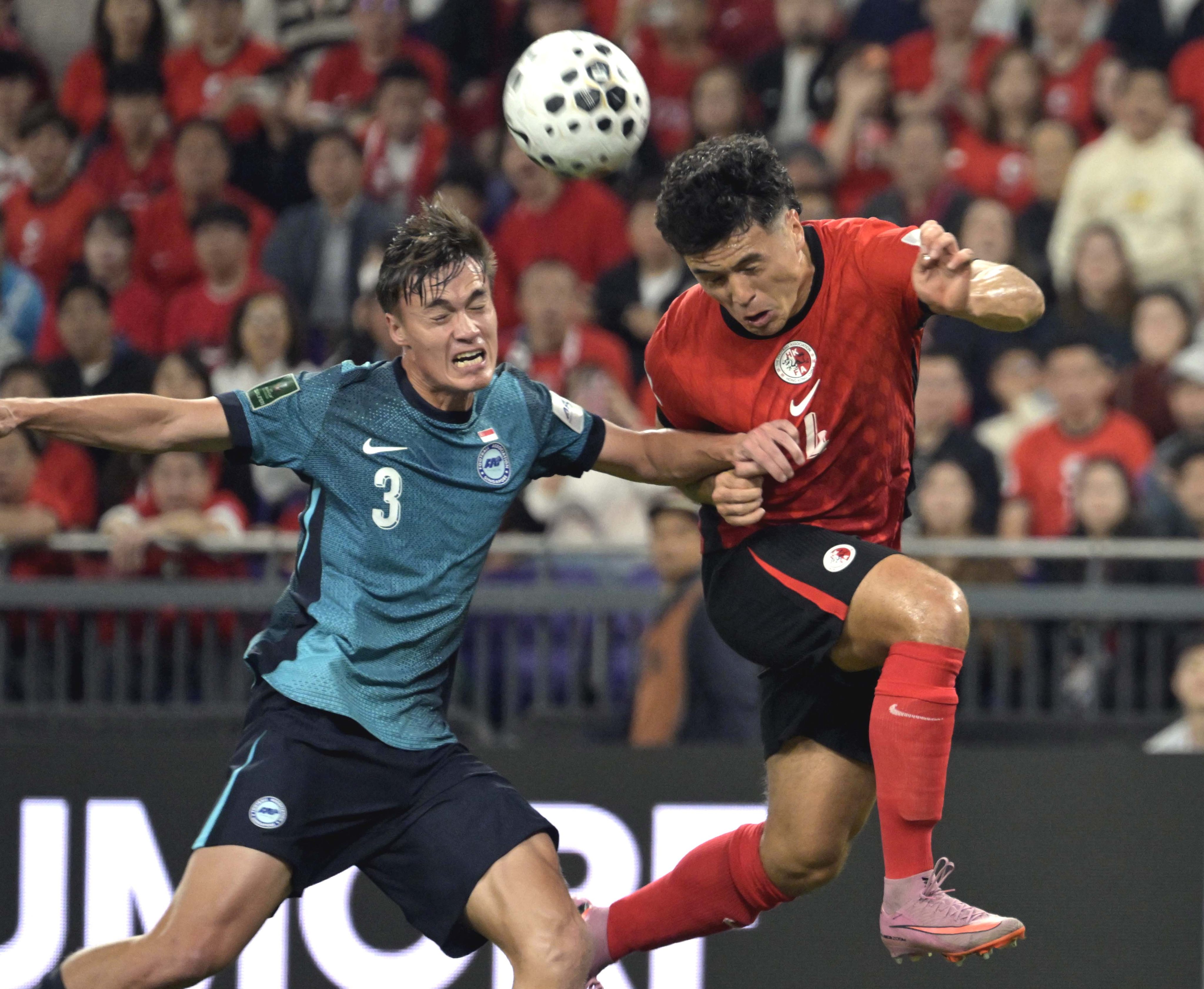 Leon Jones (right) of Hong Kong vies with Ryhan Stewart of Singapore during the Asian Cup Qualifiers third round group C match in Hong Kong, on November 18. Photo: Xinhua