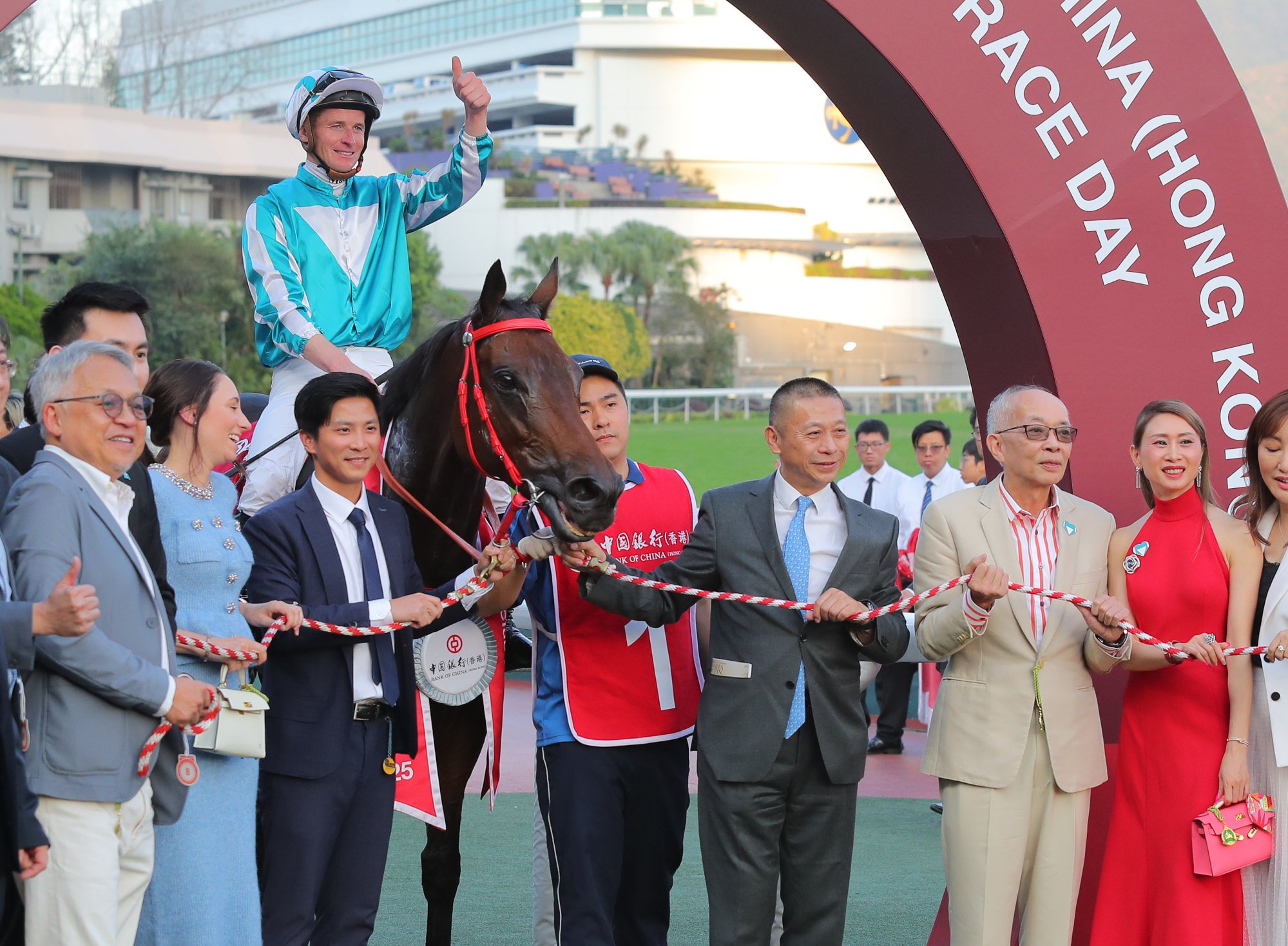 Danny Shum Chap-shing (light blue tie) and owner Peter Lau Pak-fai (next right) celebrate Romantic Warrior’s win.