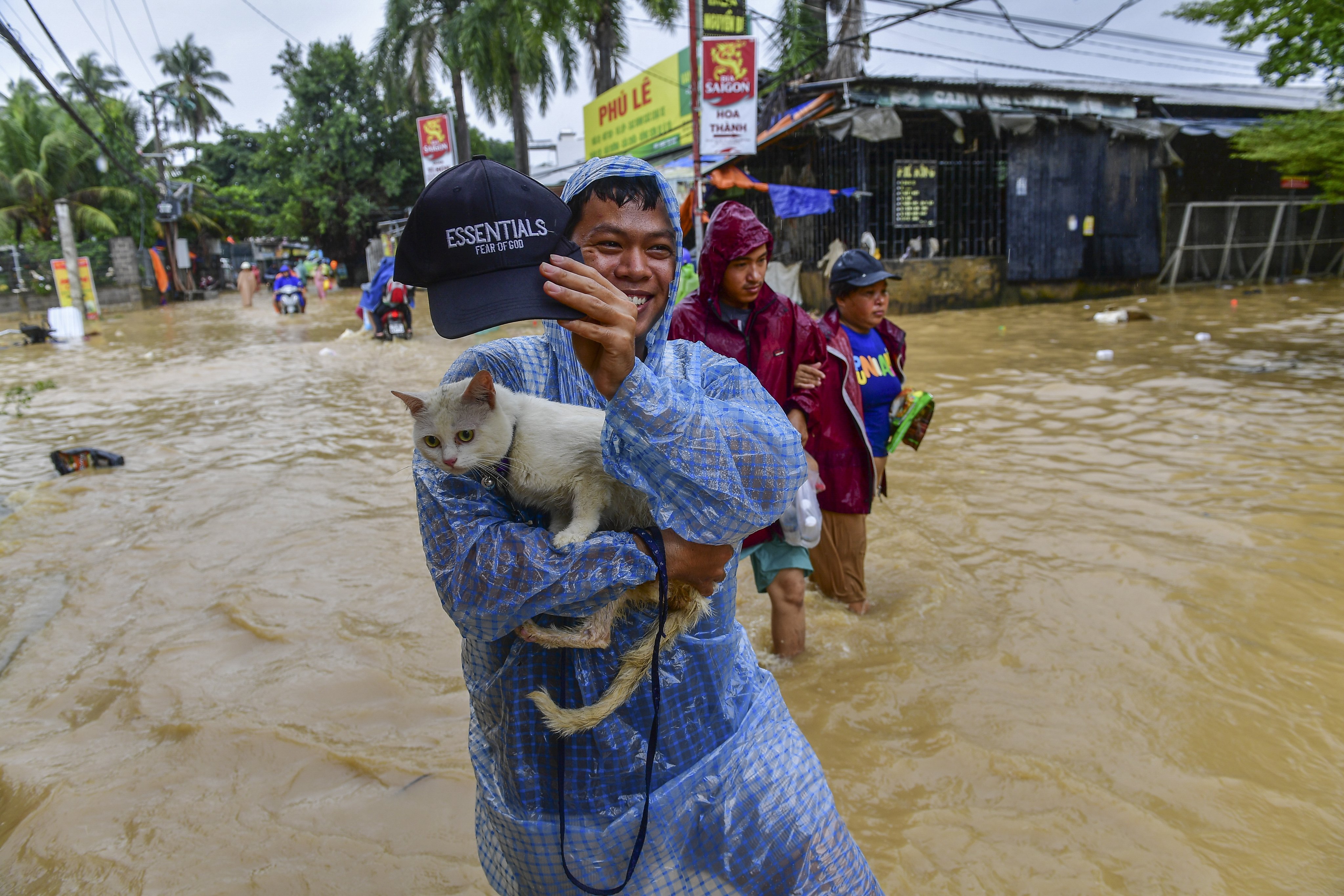 A man carrying his cat wades through flood water in Nha Trang, Khanh Hoa province, Vietnam, on Friday. Photo: EPA