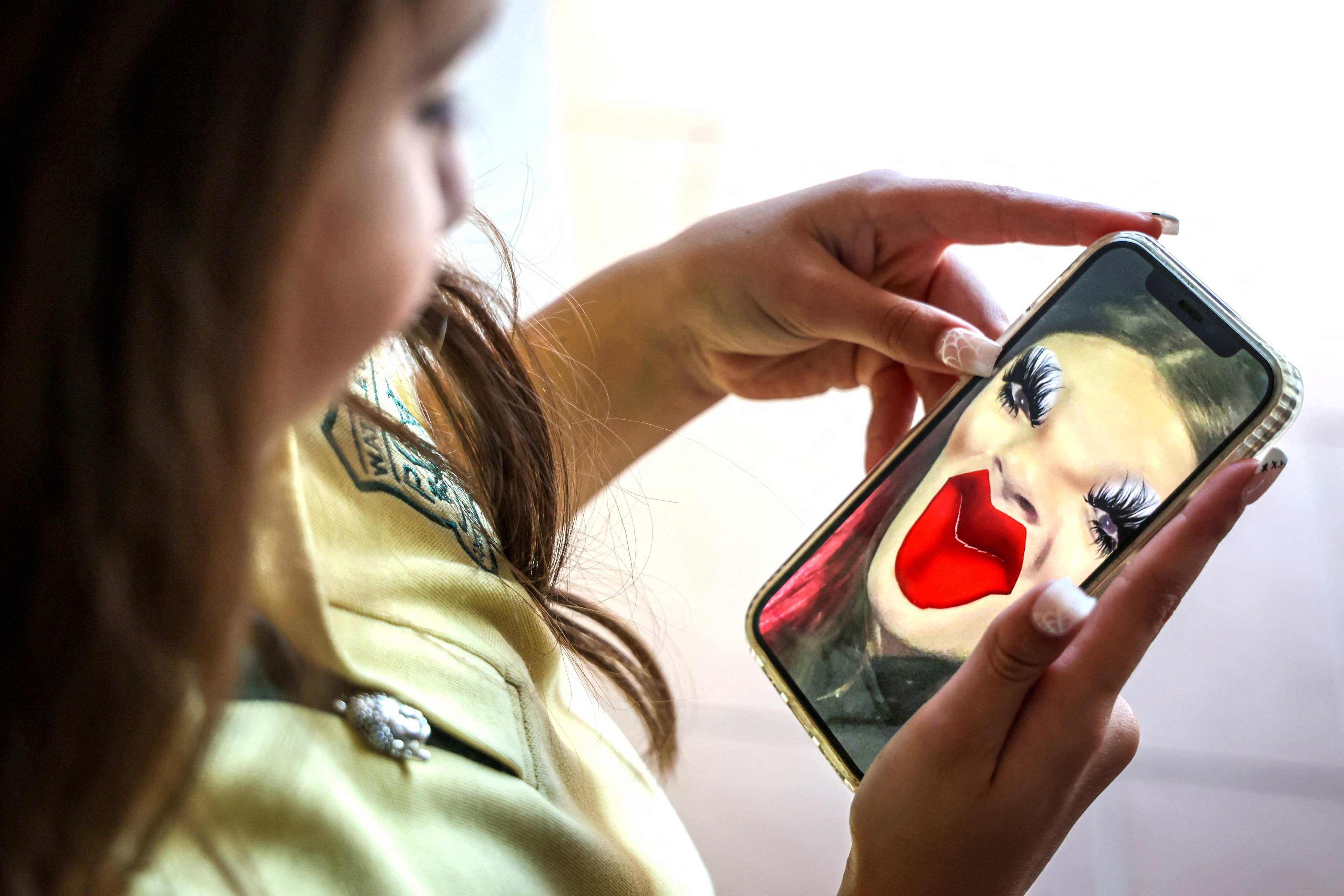 Bianca Navarro, 10, looks at a screenshot of herself using a Snapchat filter at her home in Sydney on October 30. Photo: AFP