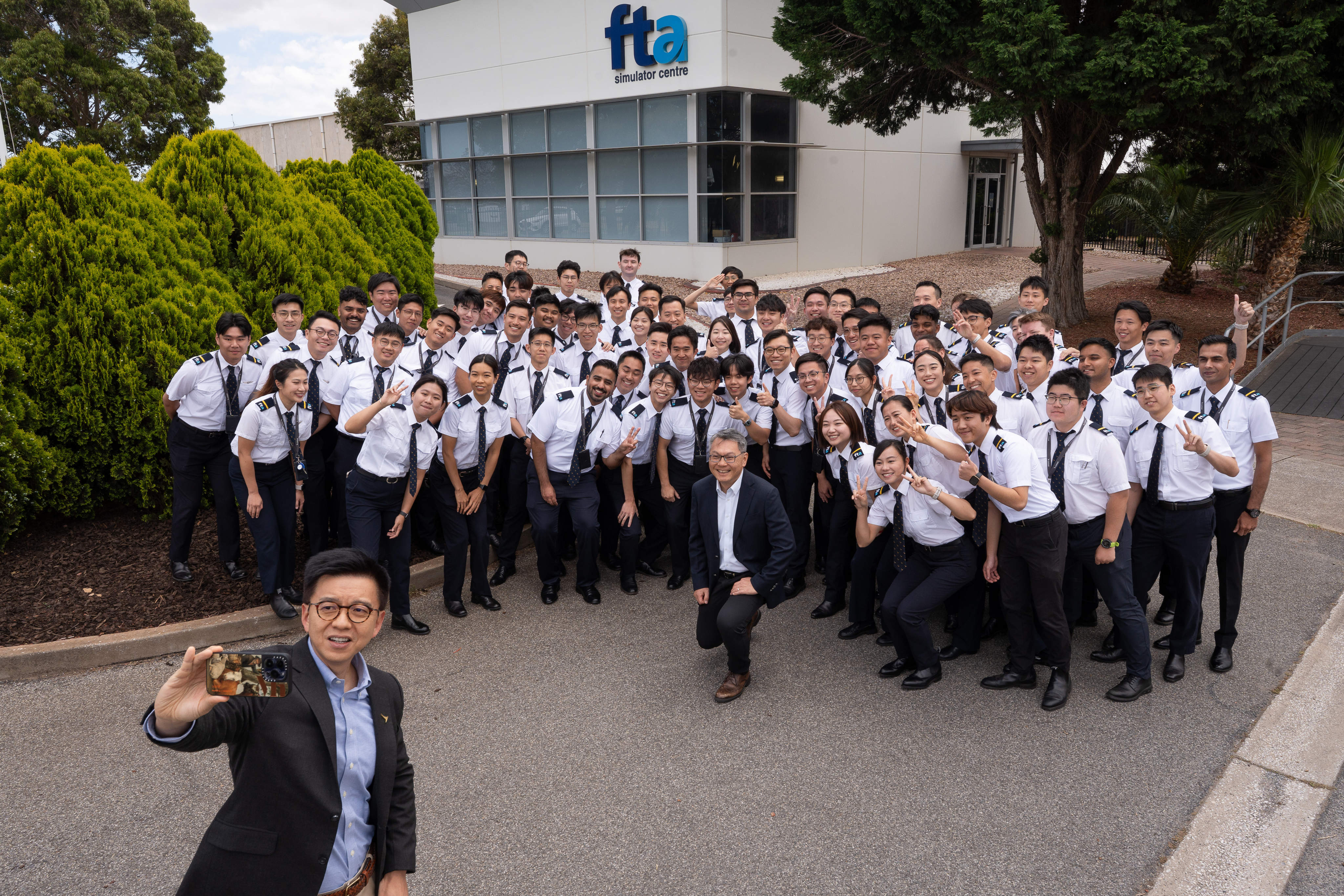 Cathay Group CEO Ronald Lam Siu-por takes a selfie with Director-General of Civil Aviation Captain Victor Liu and Cathay pilots at Flight Training Adelaide. Photo: Handout