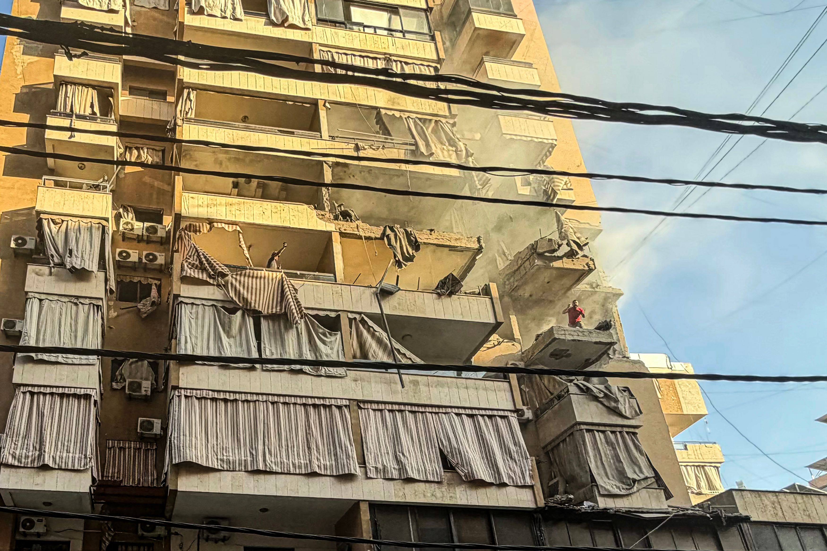 A man shouts from a balcony of a residential building targeted by an Israeli military strike in the Haret Hreik neighbourhood of Beirut’s southern suburbs. Photo: AFP