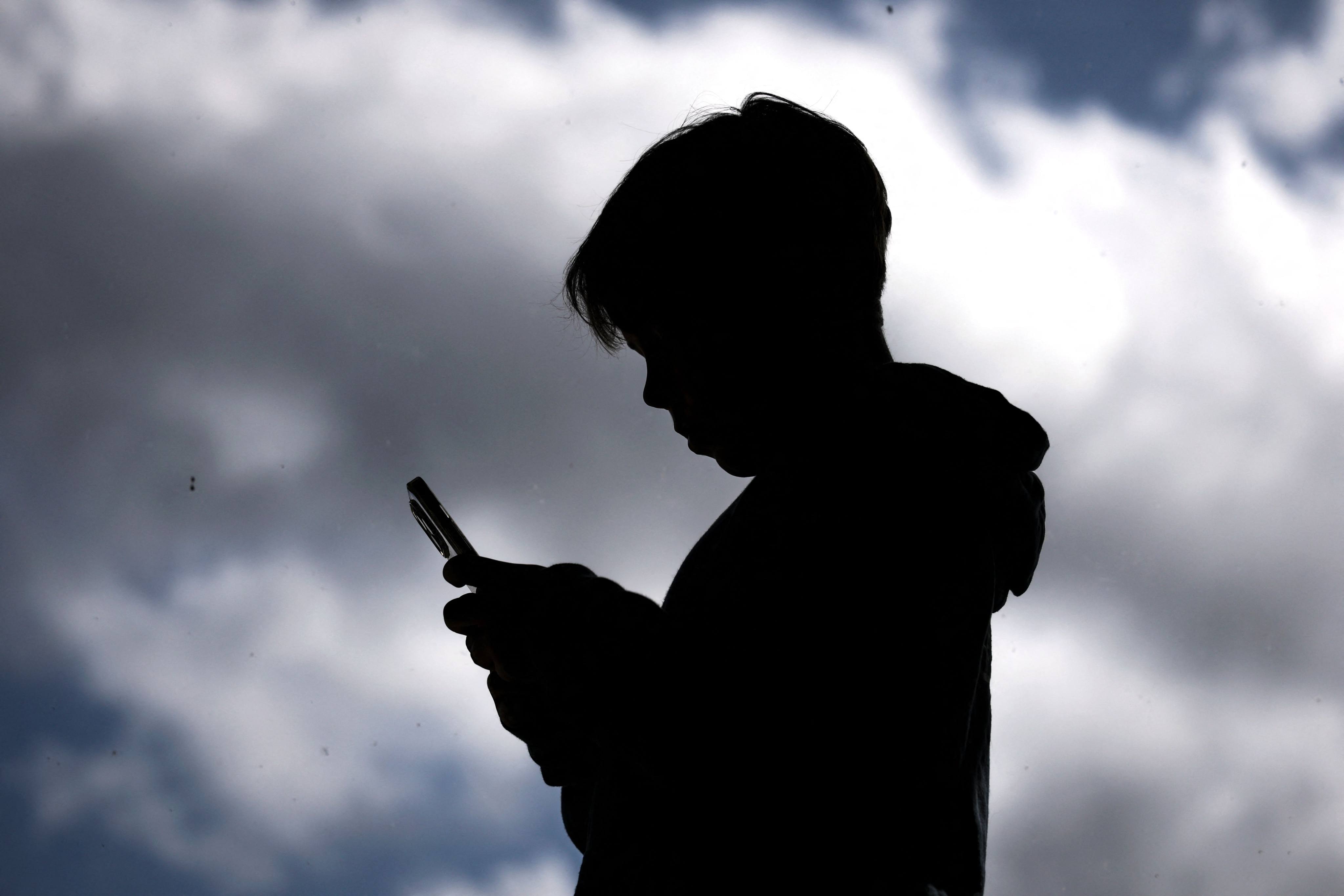 A 14-year-old boy browses social media on his phone. Starting December 10, Australia will mandate that social media platforms remove users under 16. Photo: AFP