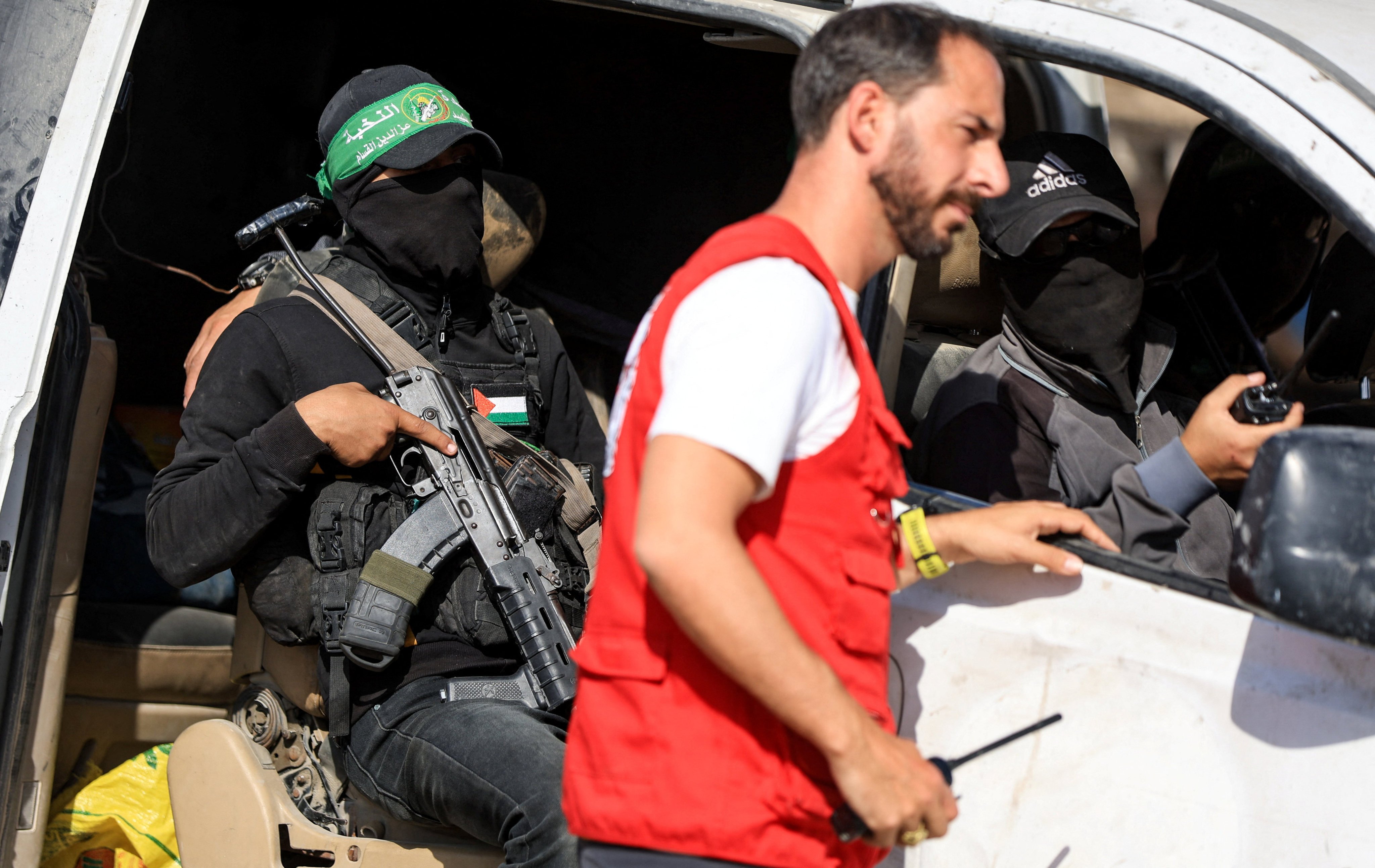 Hamas militants escort members of the Red Cross towards a designated area in Gaza last week. Photo: Reuters