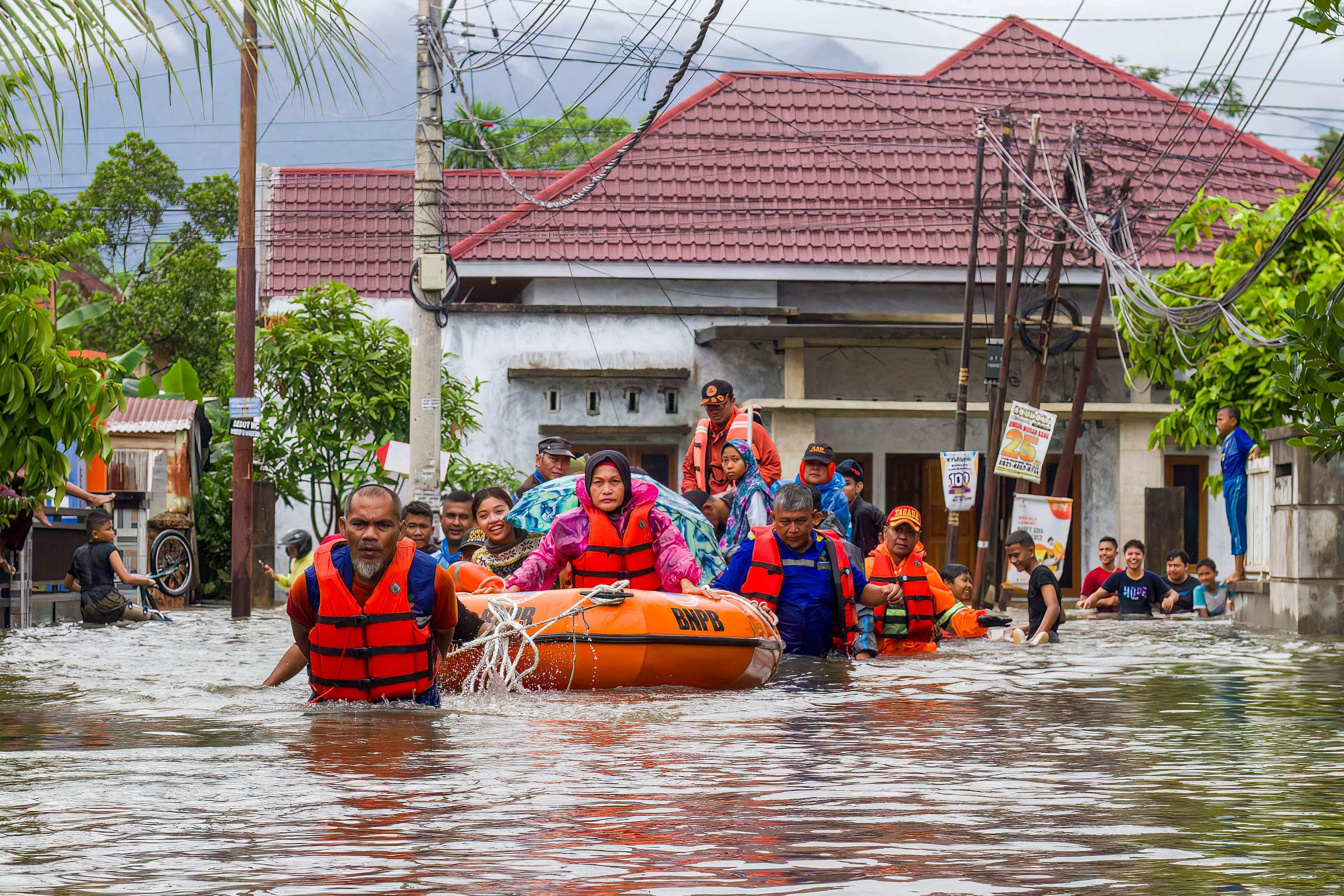 A rescue team evacuates women and children in a rubber boat as Tuesday. Photo: AFP