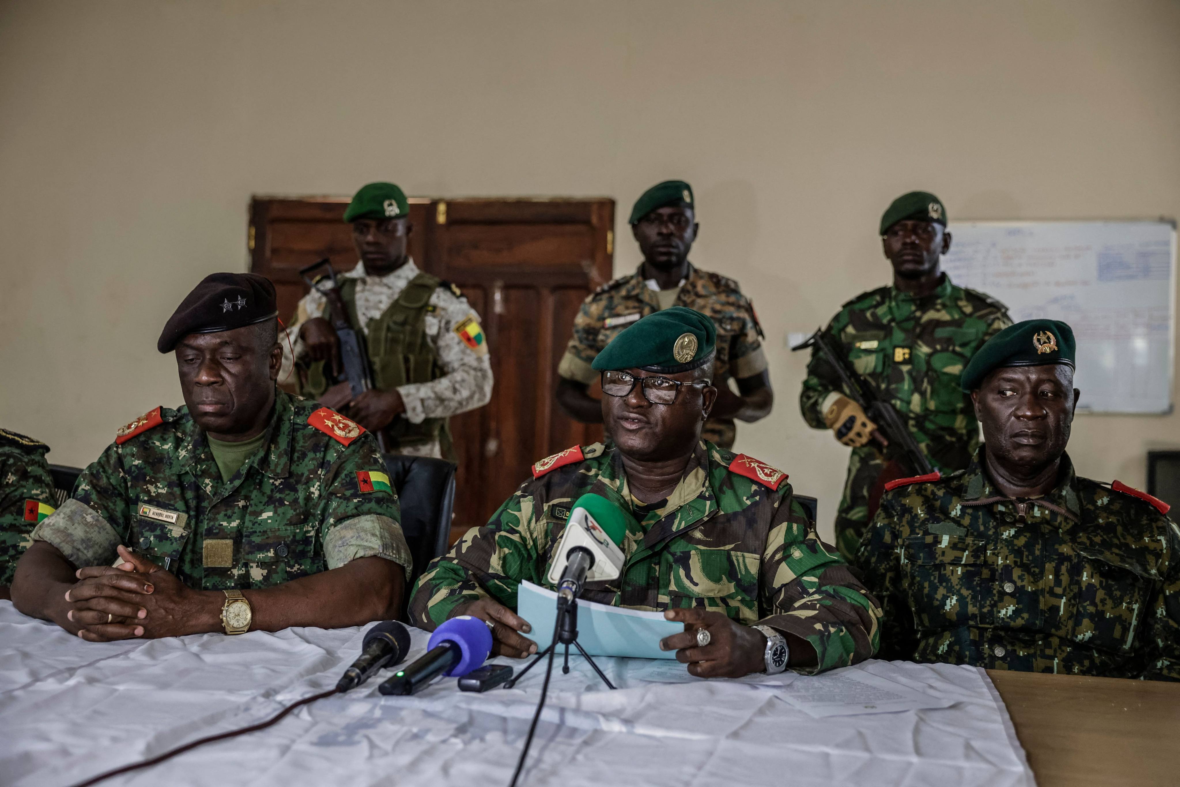 Brigadier General Dinis N’Tchama, flanked by others during a televised statement. Photo: AFP