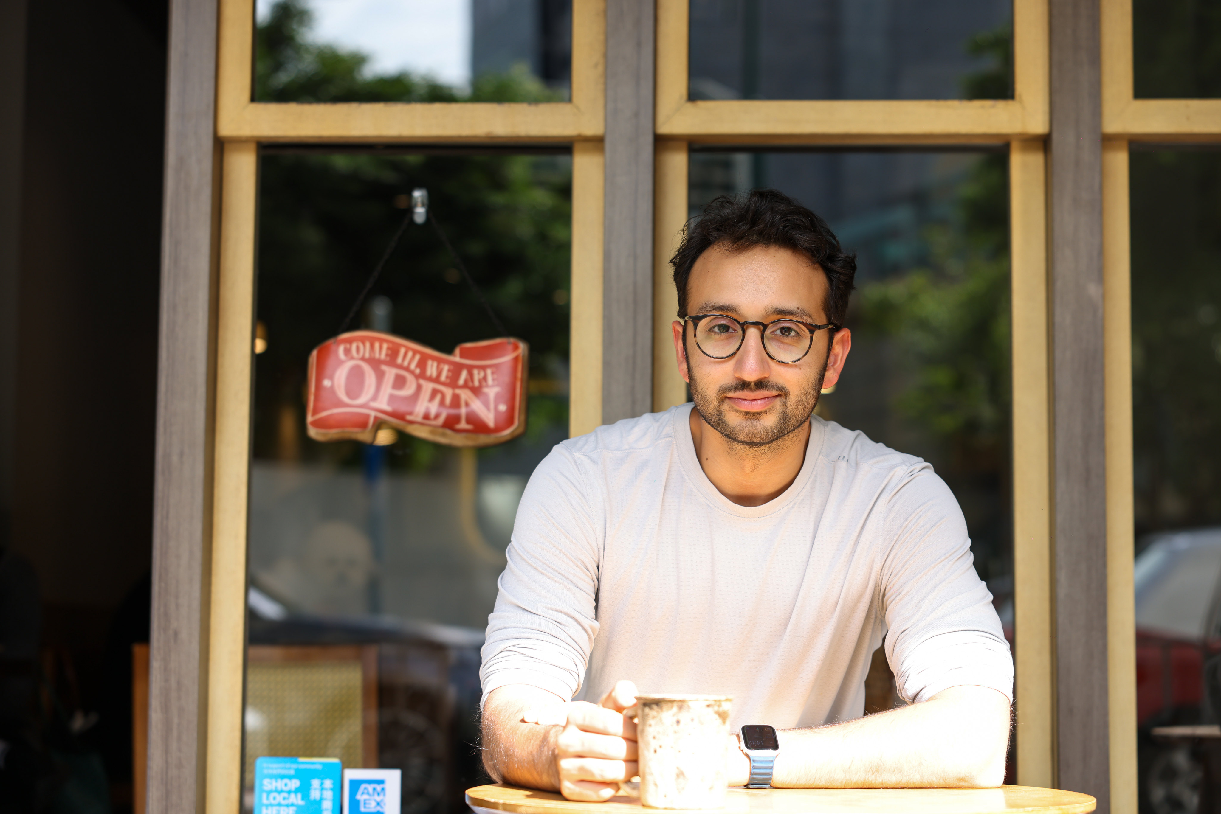 Ali Abdaal, a former doctor who is now a digital creator, entrepreneur and YouTube star, sits at a cafe in Causeway Bay. Abdaal will speak at the Hong Kong Jockey Club Amphitheatre on December 8 to explain how to make 2026 “the best year of your life”. Photo: Nora Tam