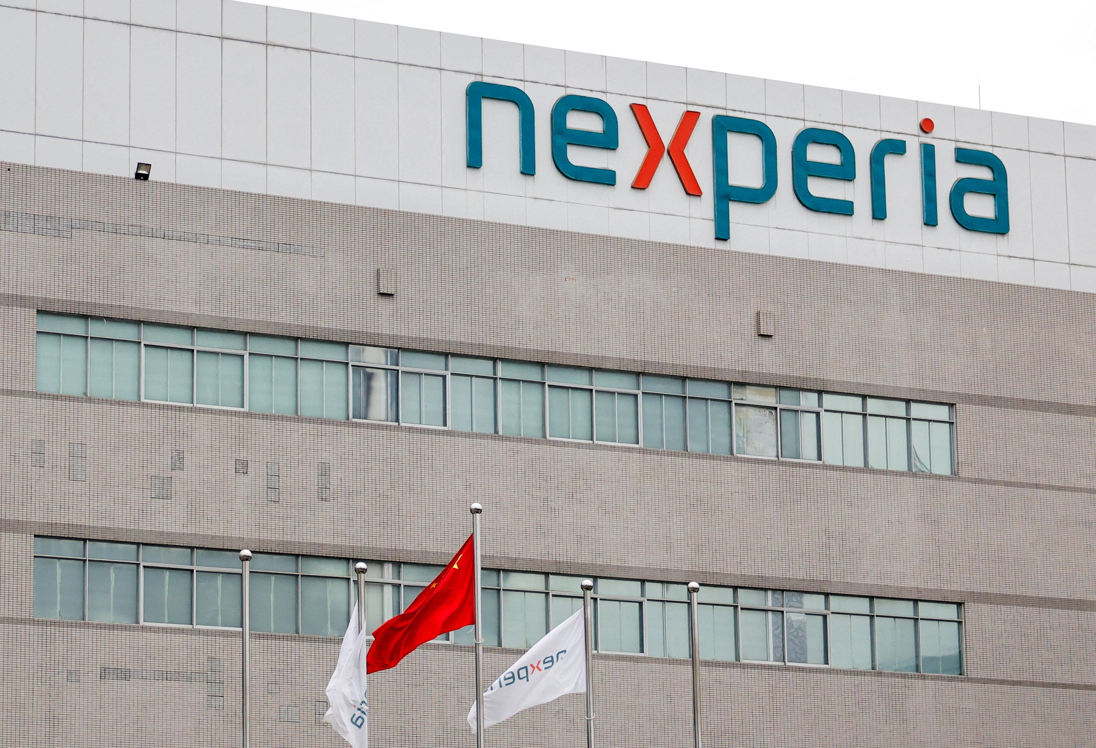 Flags fly next to a logo of Nexperia at the facade of its factory in Guangdong province amid a chip-supply shortage caused by a diplomatic standoff between China and the Netherlands over the company. Photo: Reuters