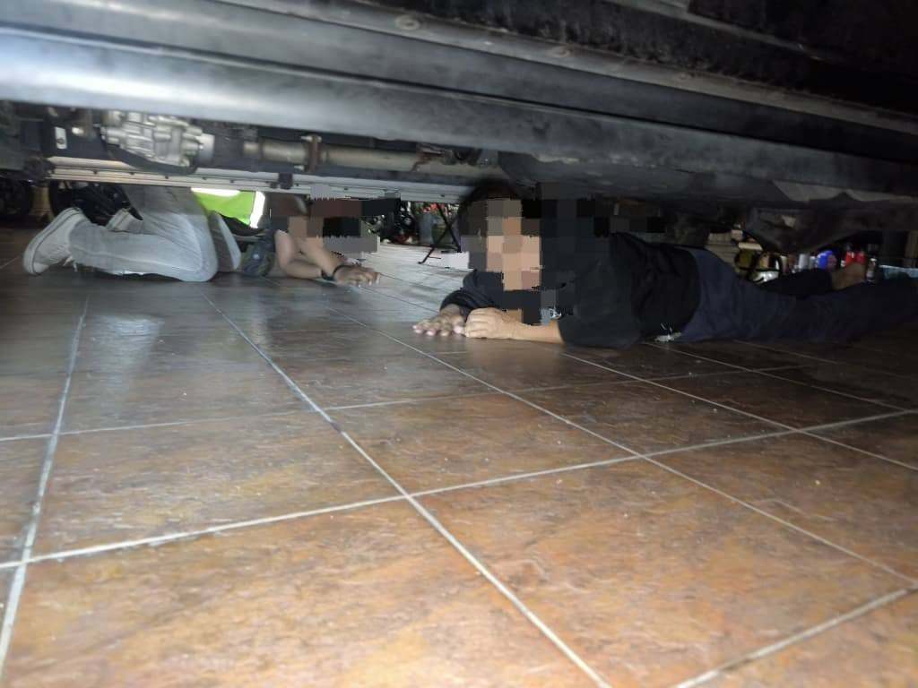 The victim was forced to hide under a vehicle to avoid detection during a raid in in Batu Caves, Malaysia. Photo: Facebook/imigresen