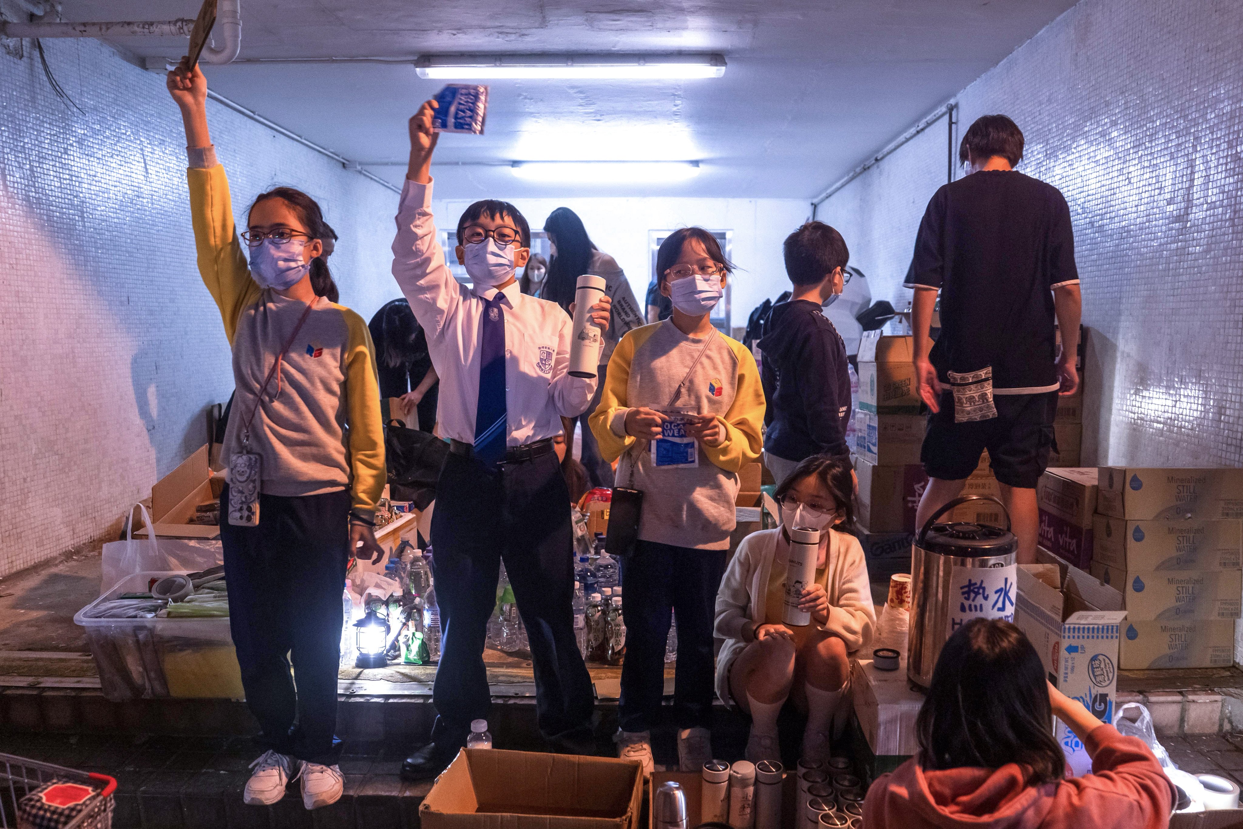 Students offer hot water and soft drinks to the residents of Wang Fuk Court in the open area of Kwong Fuk Estate on the night of November 27. Photo: Elson Li