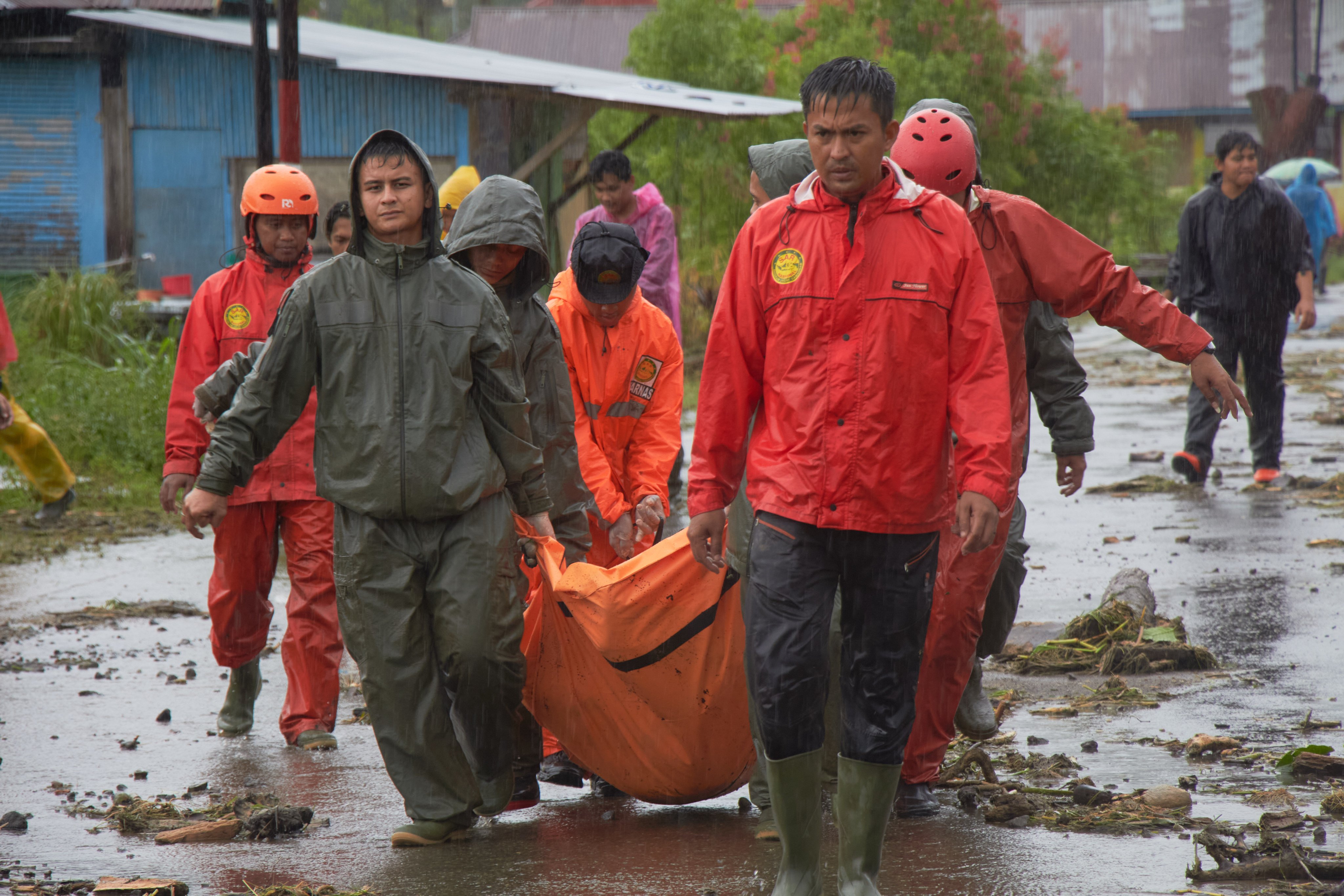 Rescuers carry the body of a victim at a village hit by a flood in Malalak, West Sumatra, Indonesia, on Friday. Photo: AP