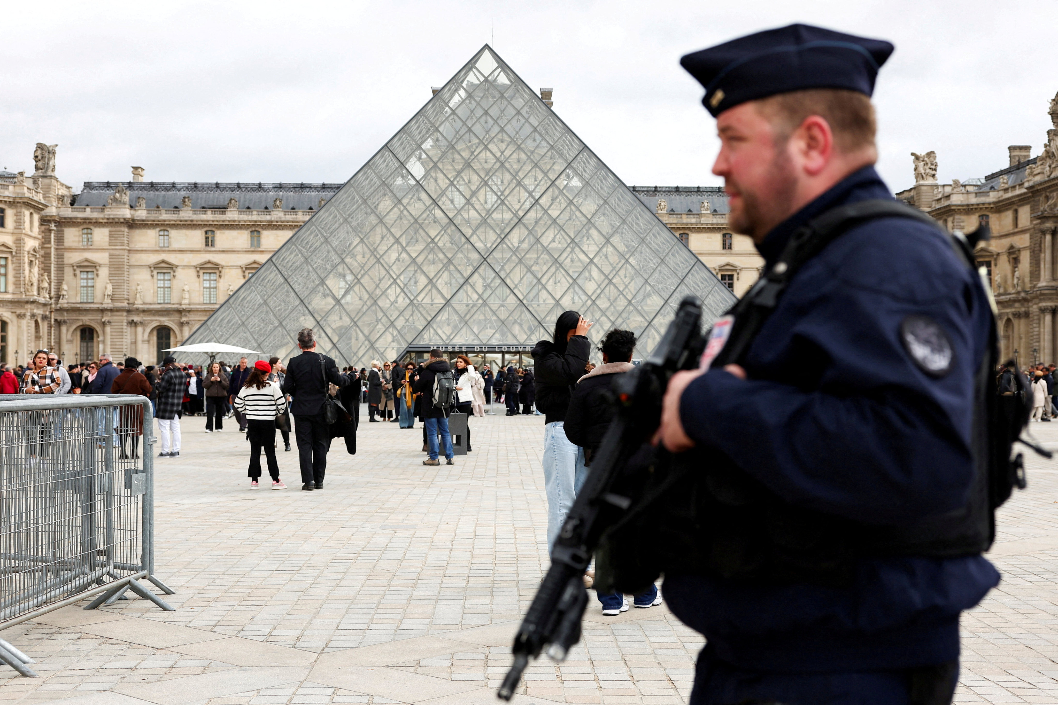 A French riot police officer patrols near the glass Pyramid of the Louvre Museum last month, after French police arrested suspects allegedly involved in a jewellery heist. Photo: Reuters