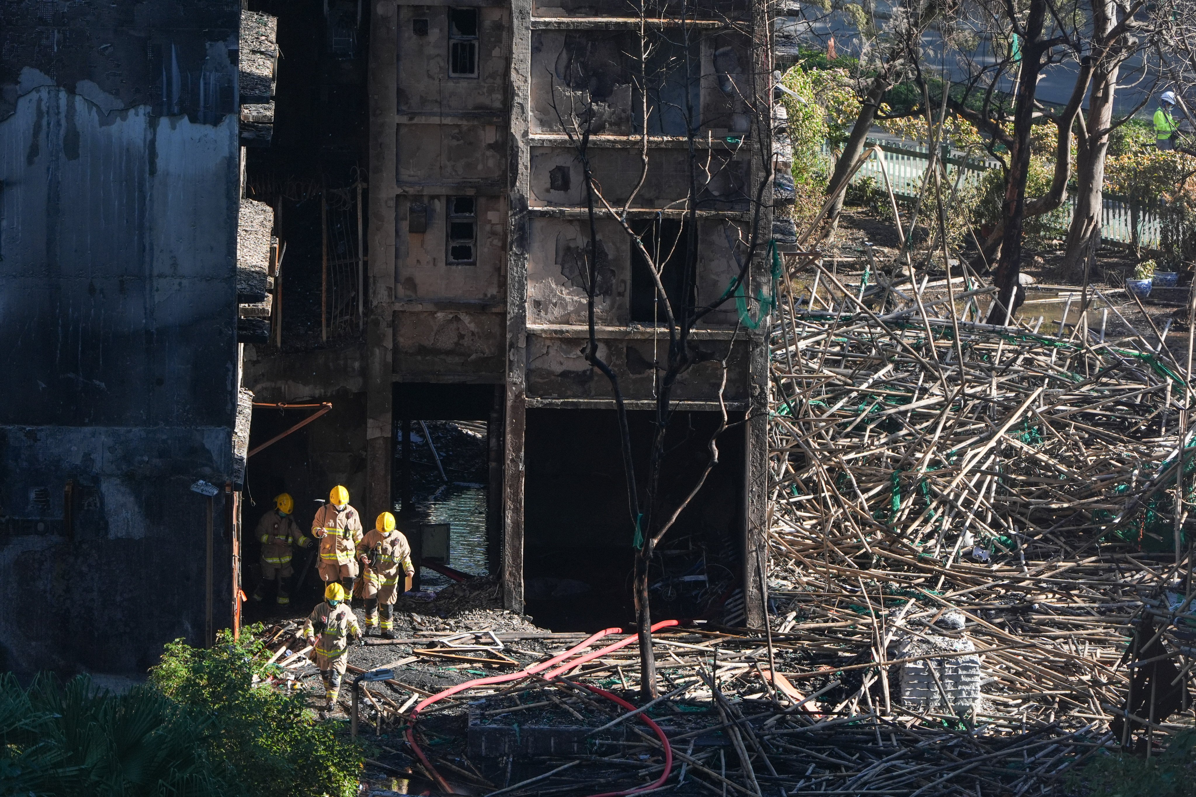 Firefighters walk out of a building at Wang Fuk Court in Tai Po after the deadly fire. Photo: Eugene Lee