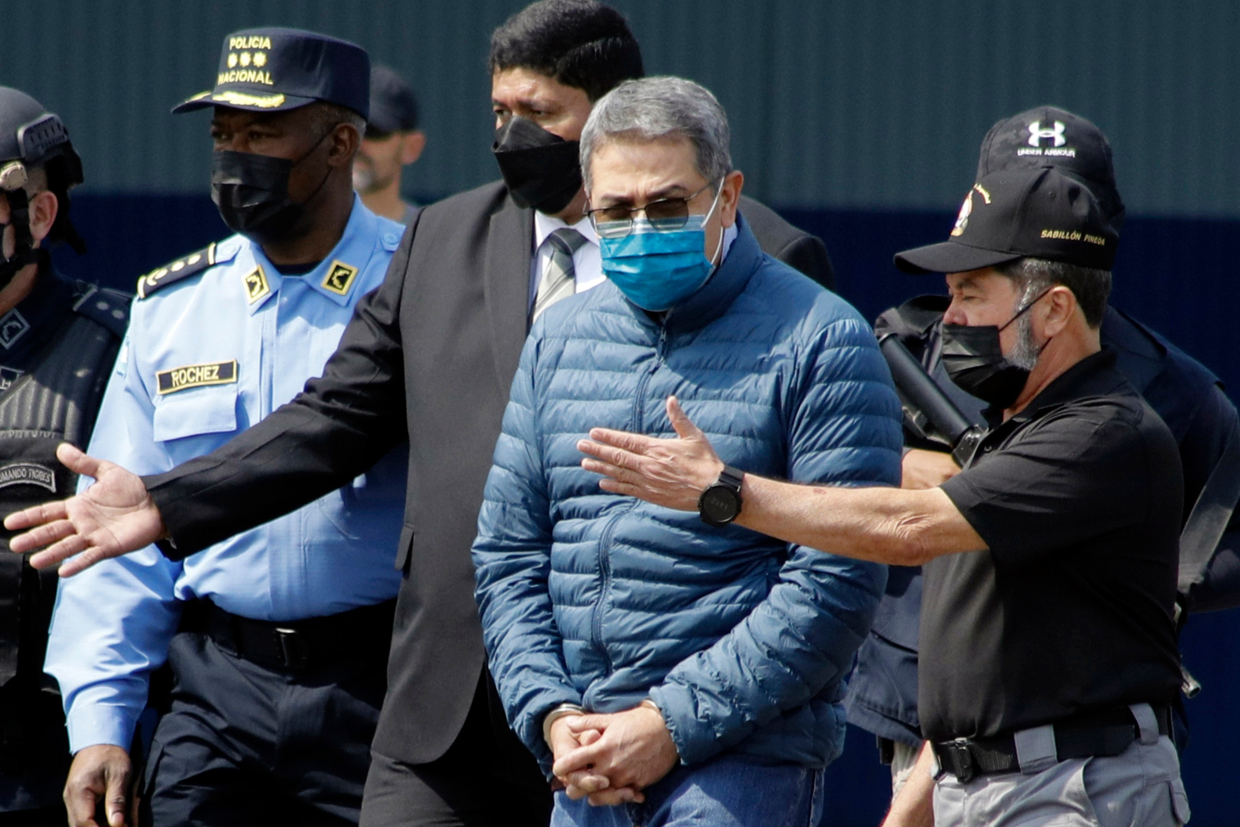 Former Honduran president Juan Orlando Hernandez is taken in handcuffs to a waiting aircraft for extradition to the US at an Air Force base in Tegucigalpa, Honduras, in April 2022. Photo: AP