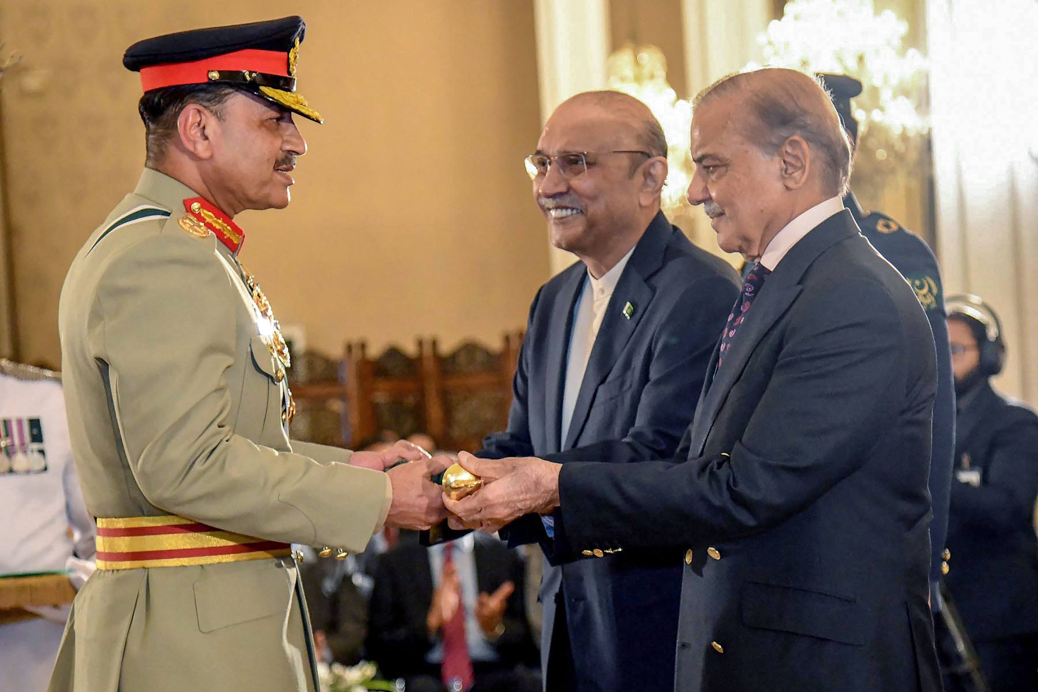 Pakistan’s Prime Minister Shehbaz Sharif (right) and President Asif Ali Zardari (centre) jointly conferring the Baton of Field Marshal on Chief of Army Staff General Syed Asim Munir during a ceremony at the country’s President House in Islamabad on May 22. Photo: AFP