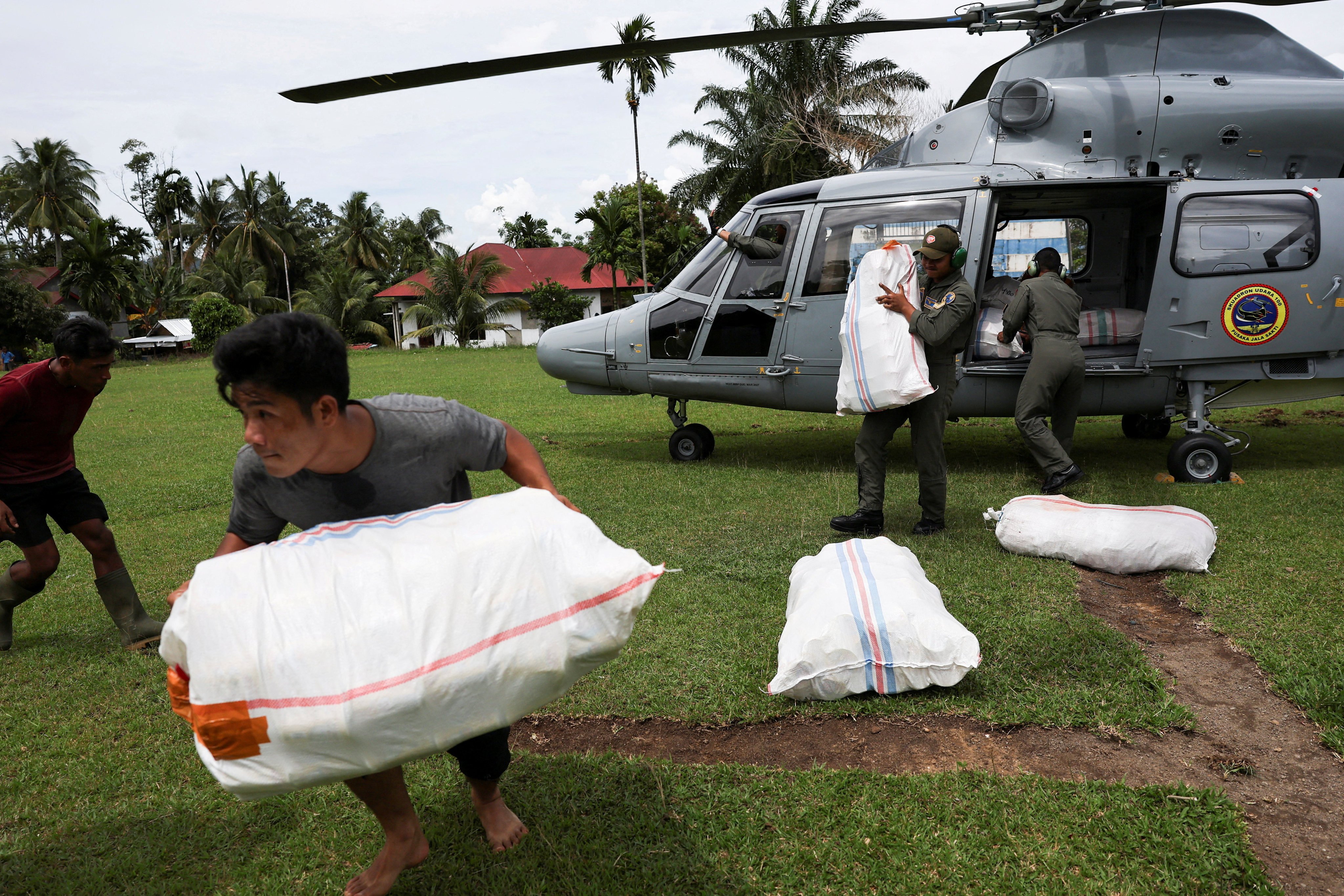 A man moves relief supplies delivered by a Navy helicopter in an area affected by deadly flash floods in Palembayan, Agam regency, West Sumatra province, Indonesia, on Saturday. Photo: Reuters