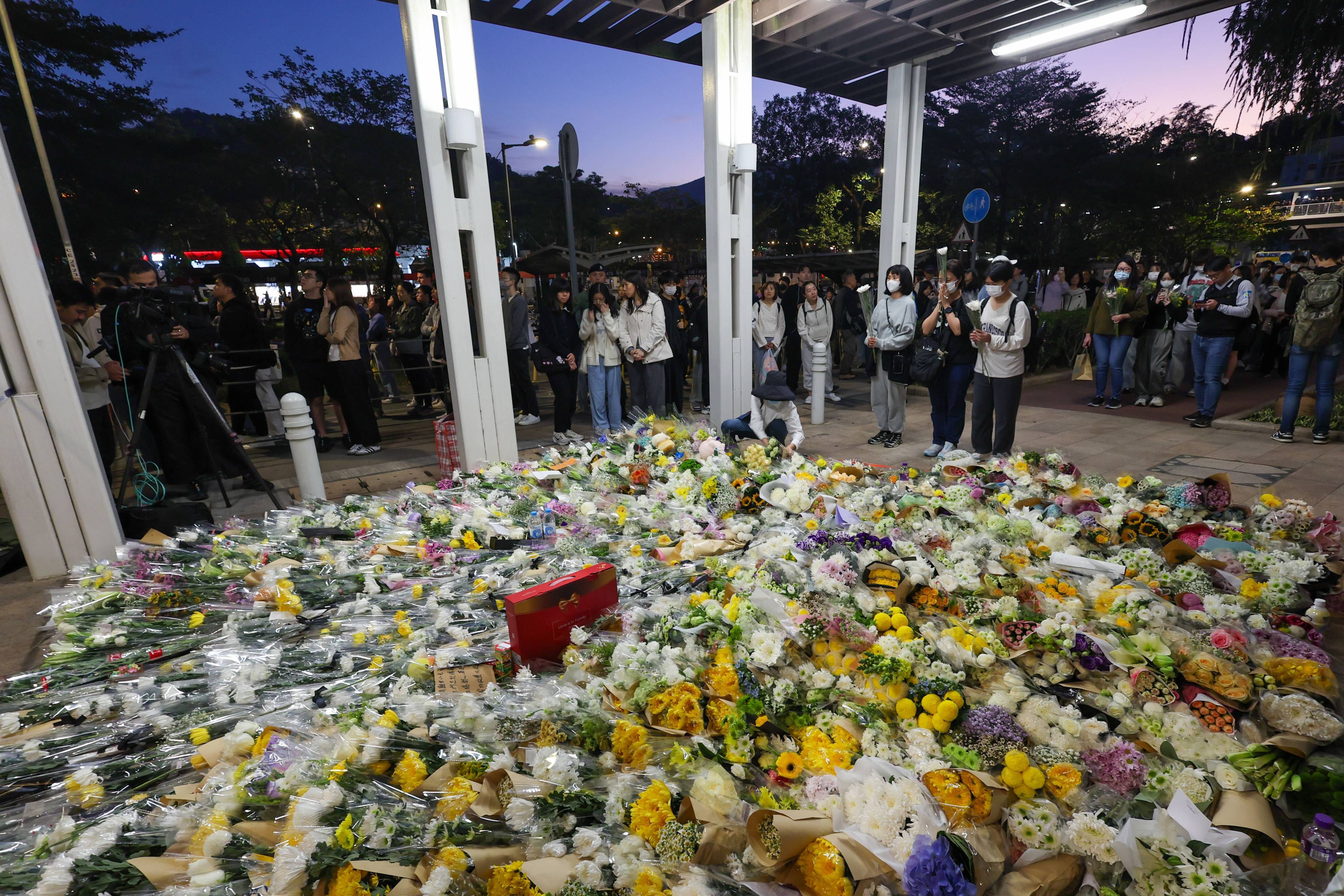 Hundreds of people queue up at night to pay tributes and mourn the victims of the fatal fire in Tai Po, on November 29. Photo: Dickson Lee