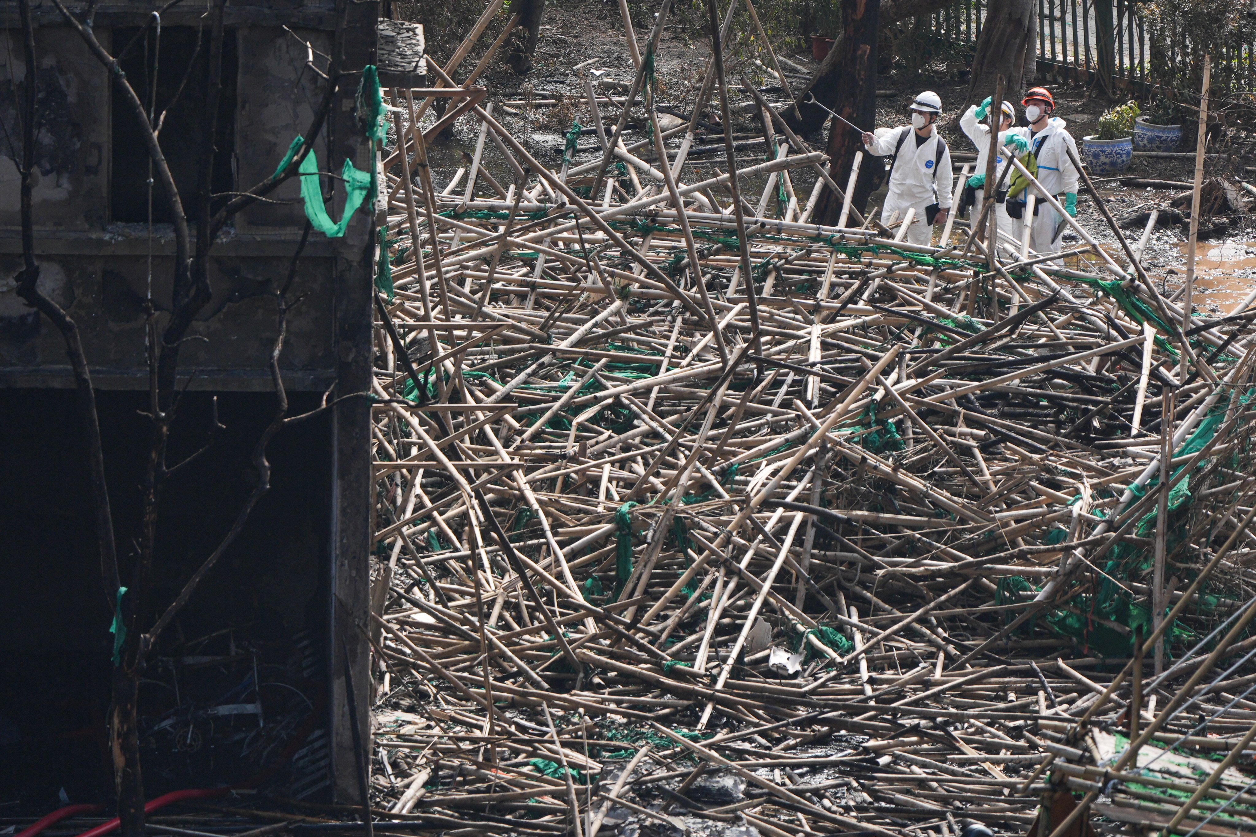 Members of the Disaster Victim Identification Unit inspect the scene of the fire at Wang Fuk Court in Tai Po. Photo: Eugene Lee