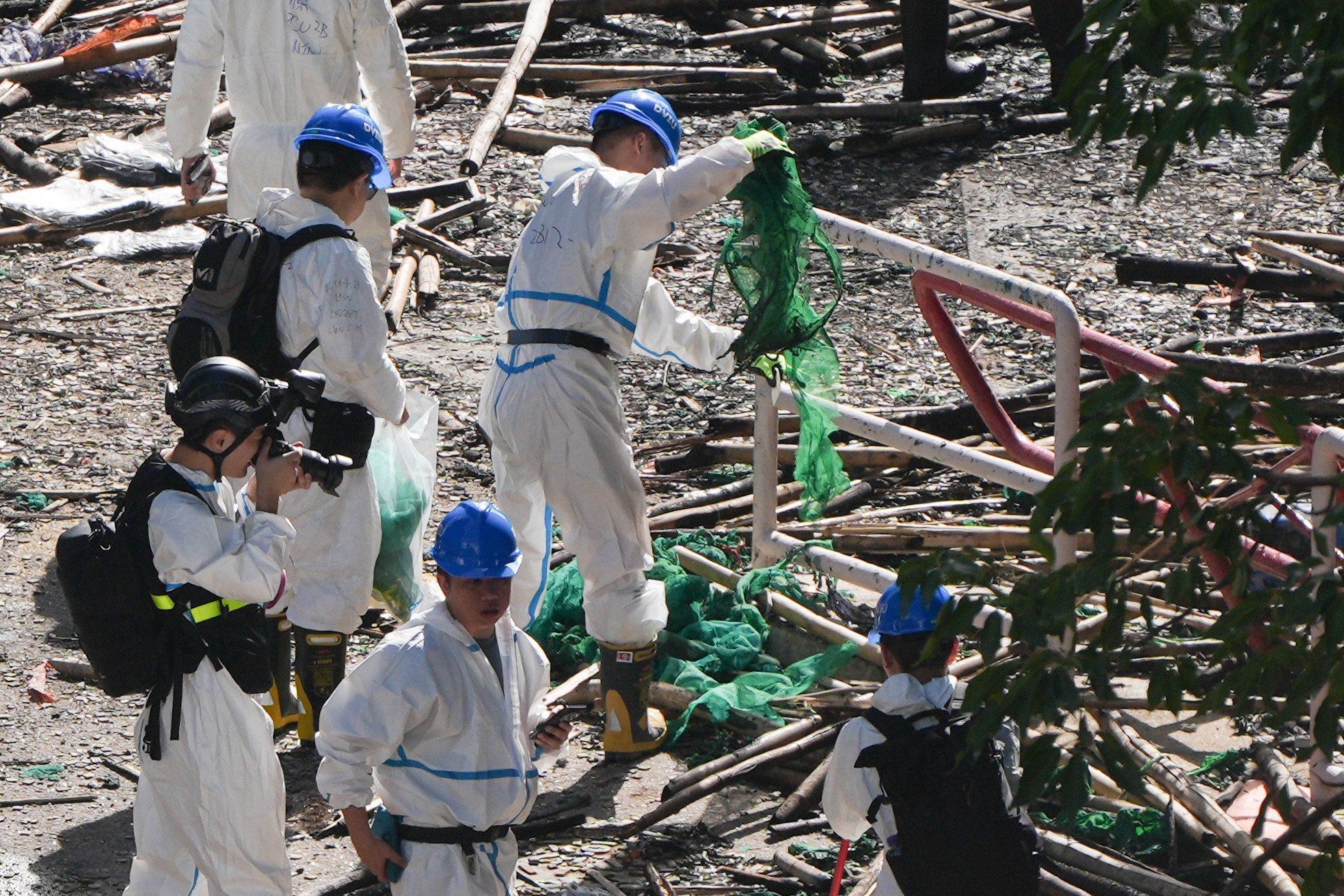 DVIU squad members search for evidence at the scene of the Tai Po fire. Photo: Eugene Lee