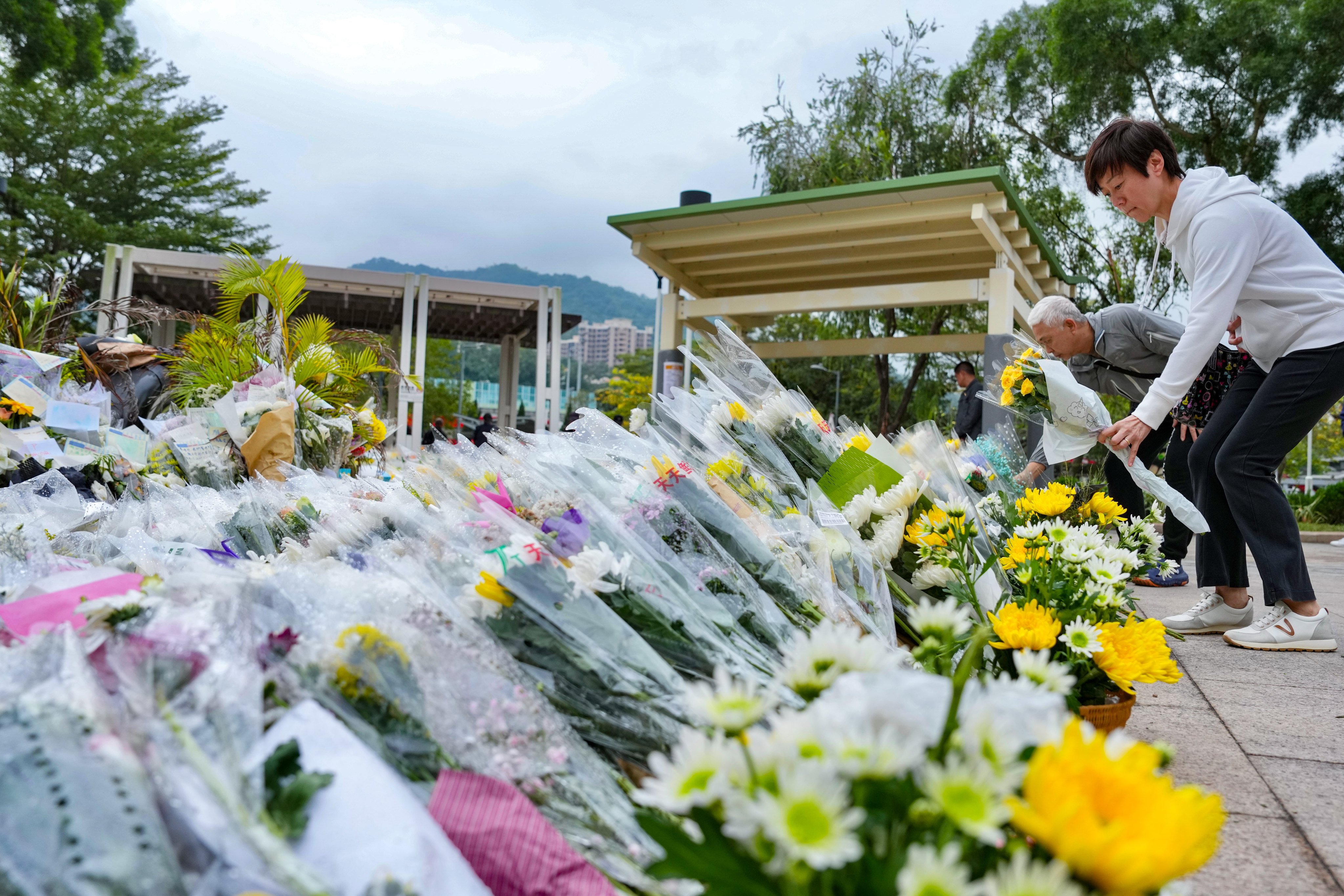Hongkongers lay flowers in tribute to the 151 people who perished in the fire. Photo: Karma Lo