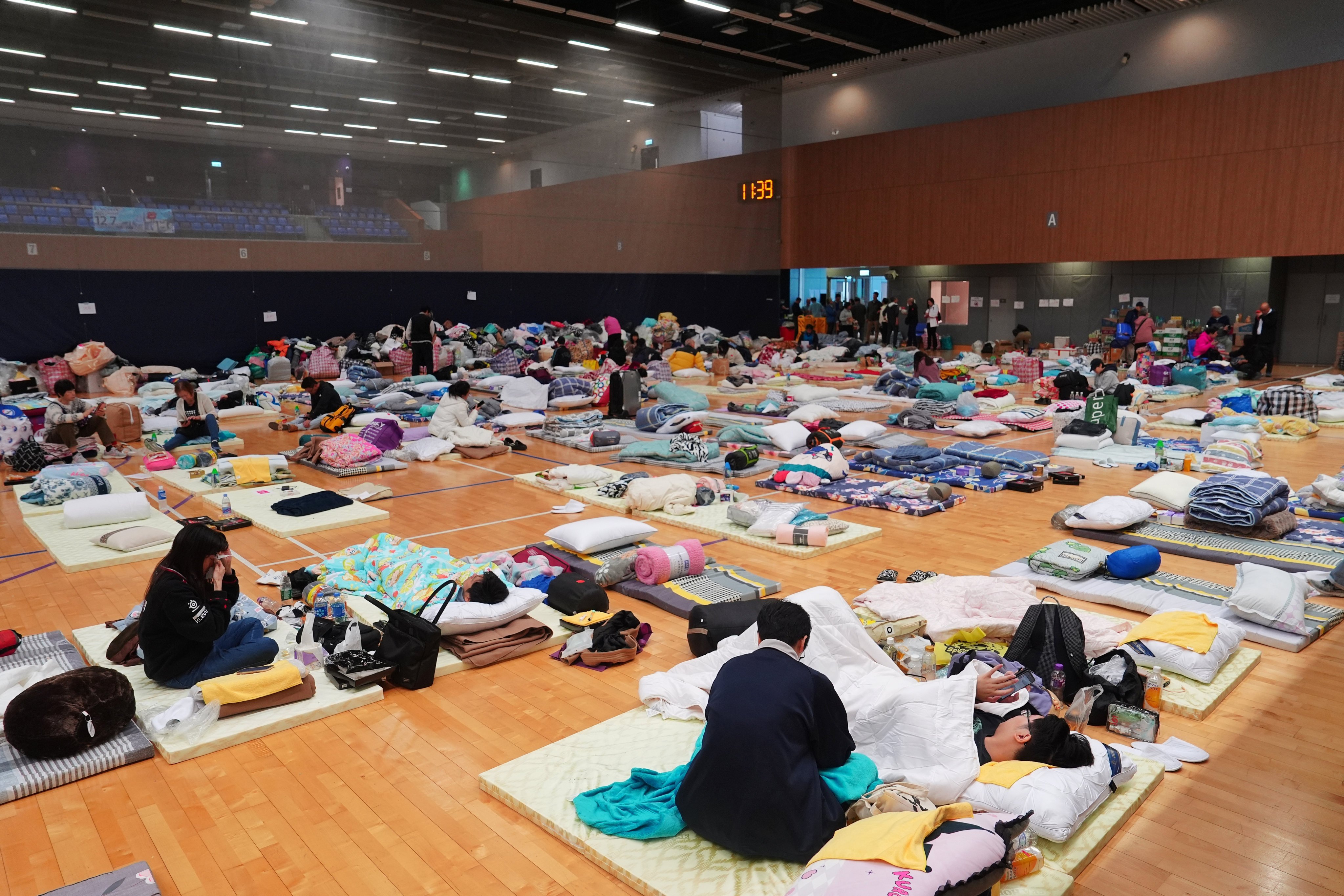 People affected by the deadly fire at Wang Fuk Court wait at a temporary shelter at Tung Cheong Street Sports Centre. Photo: Elson Li