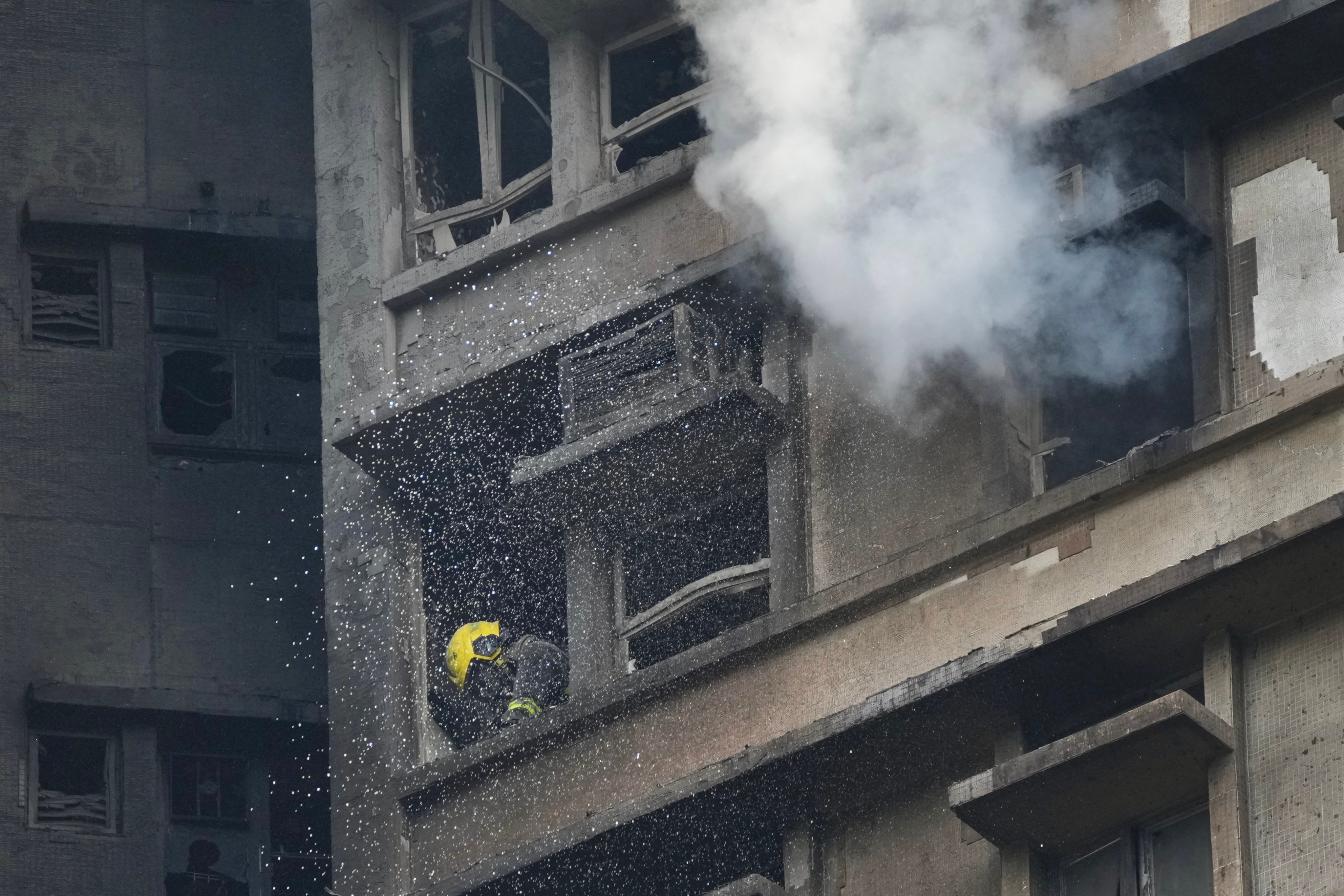 A firefighter works in a flat in one of the eight blocks of Wang Fuk Court in Tai Po on the afternoon of November 26. Photo: Karma Lo