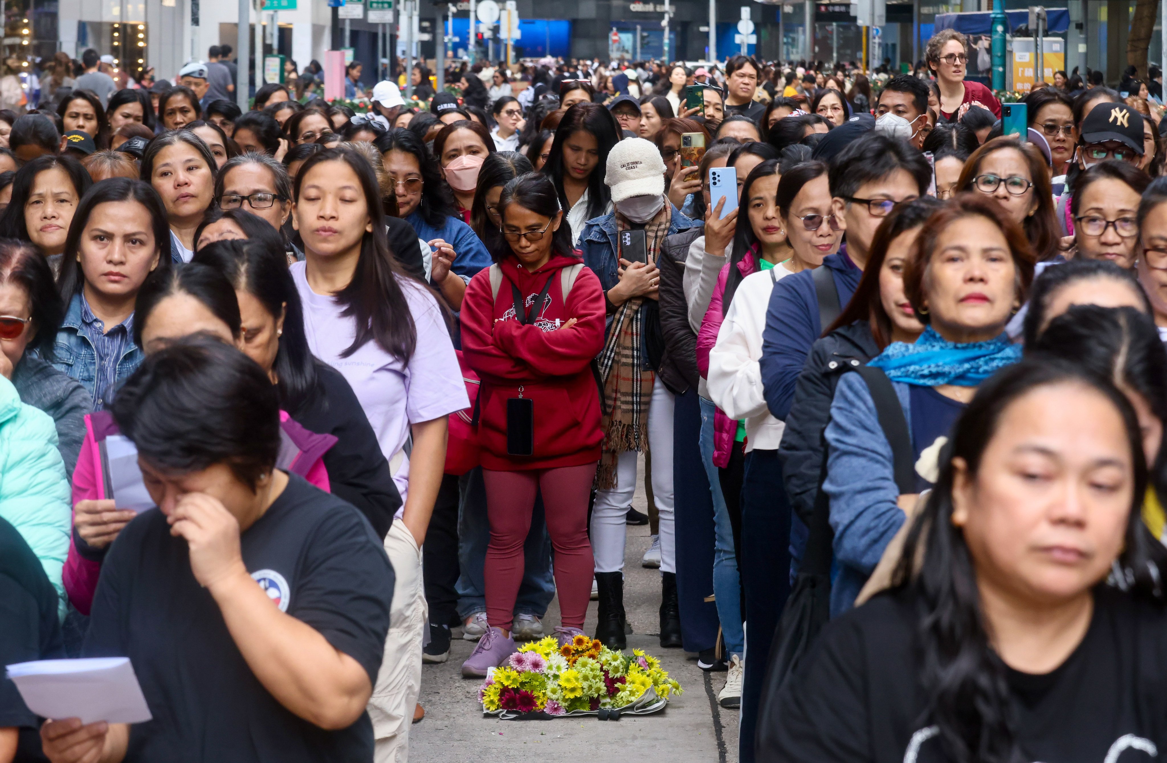 Domestic helpers say prayers at their usual Sunday gathering spot on Chater Road in Central. Photo: Jonathan Wong