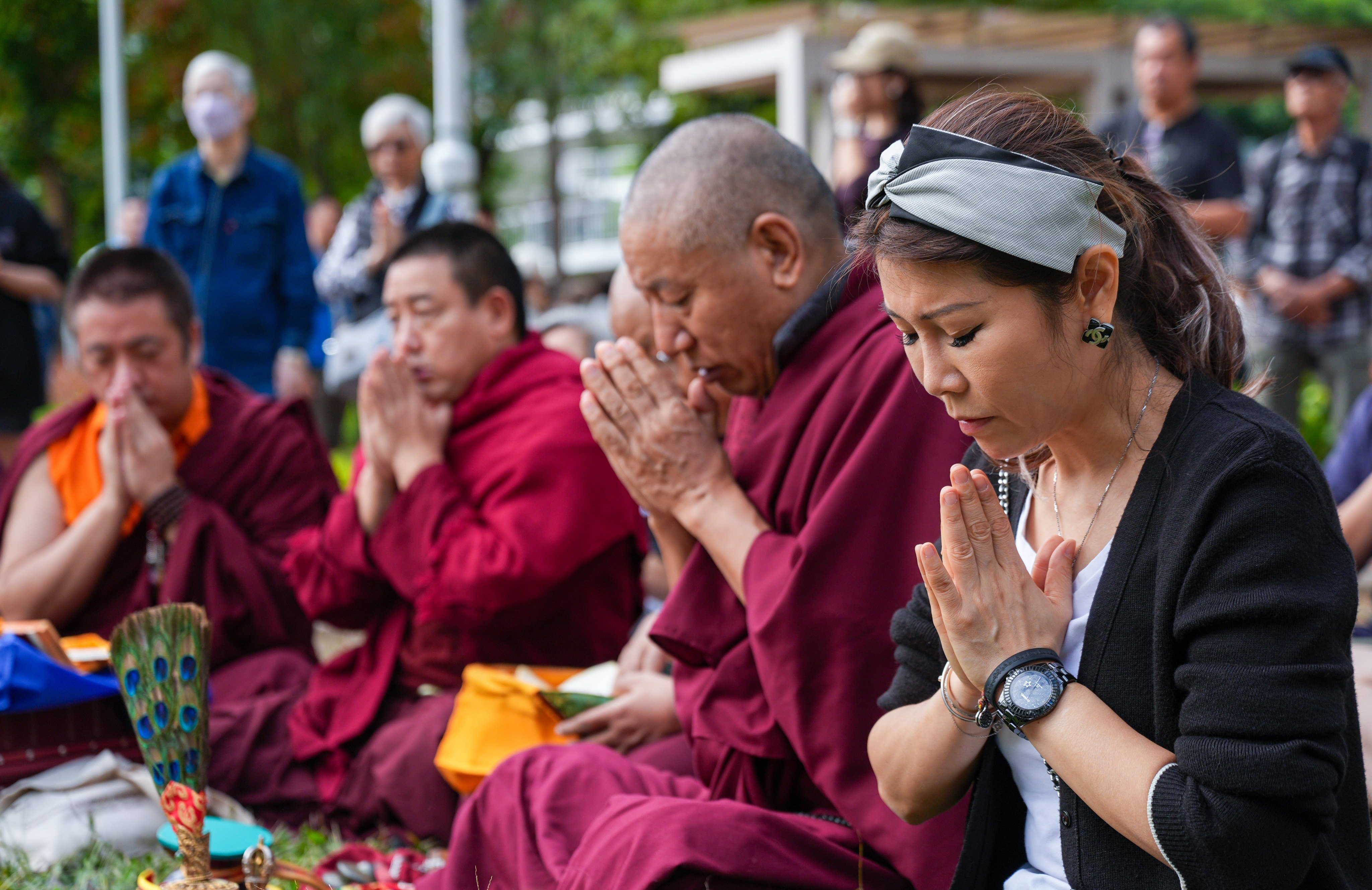 Residents and a group of Buddist monks pray for the victims of the Tai Po fire on Tuesday. Photo: Eugene Lee