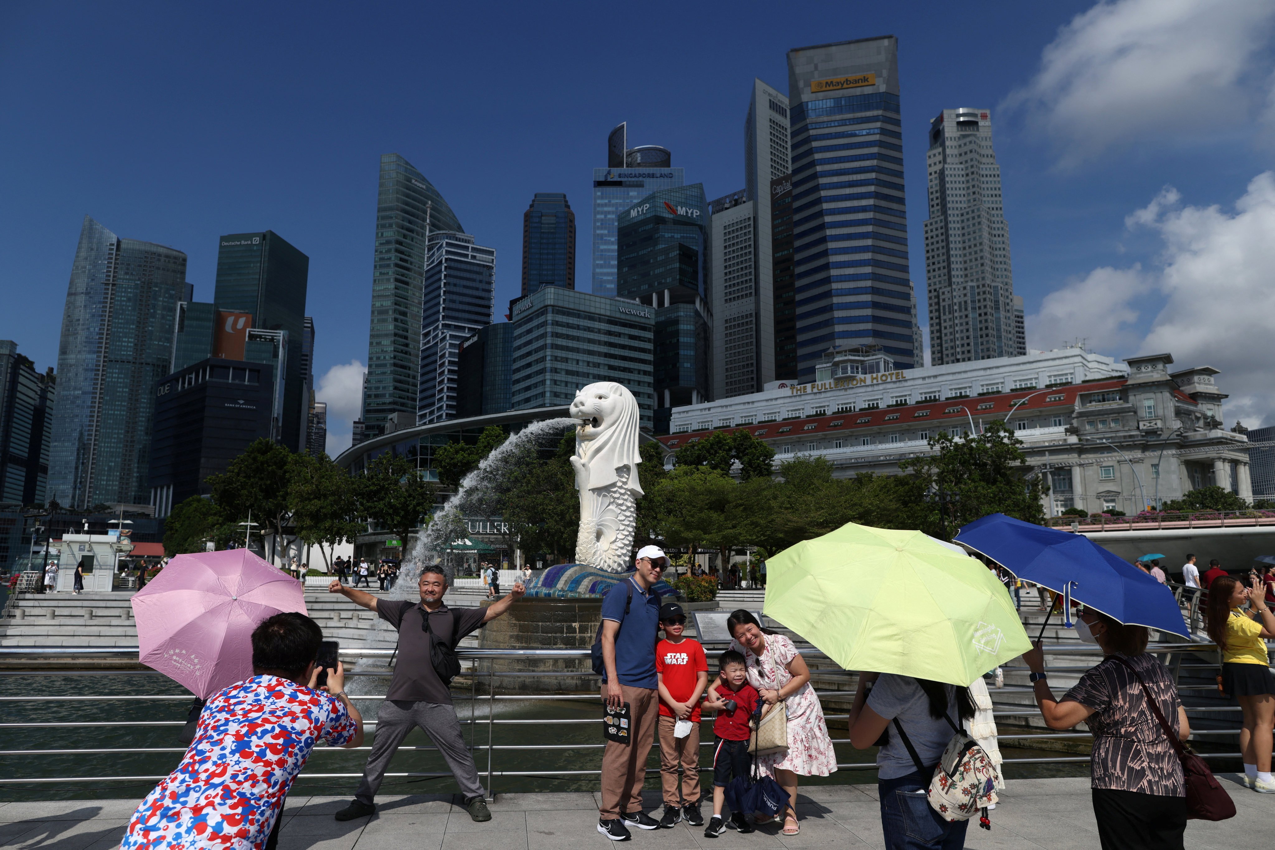 Tourists take photos with the Merlion statue in Singapore. Chinese visitors say the city state is an “easy and comfortable” travel destination. Photo: Reuters