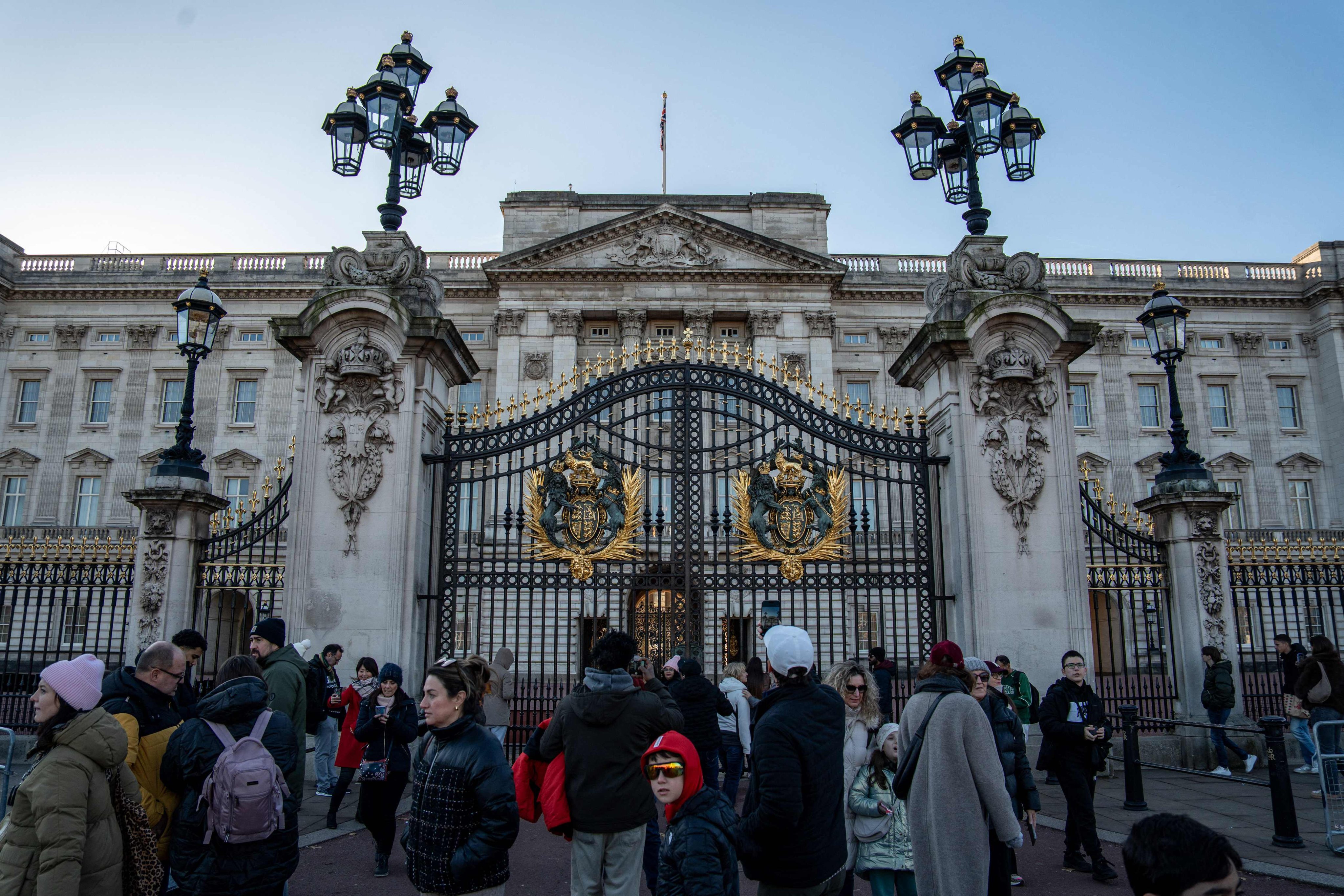 Members of the public wander in front of Buckingham Palace in London on November 21, 2025. Several content creators posted AI-generated images of a non-existent Christmas market outside the palace walls. Photo: AFP