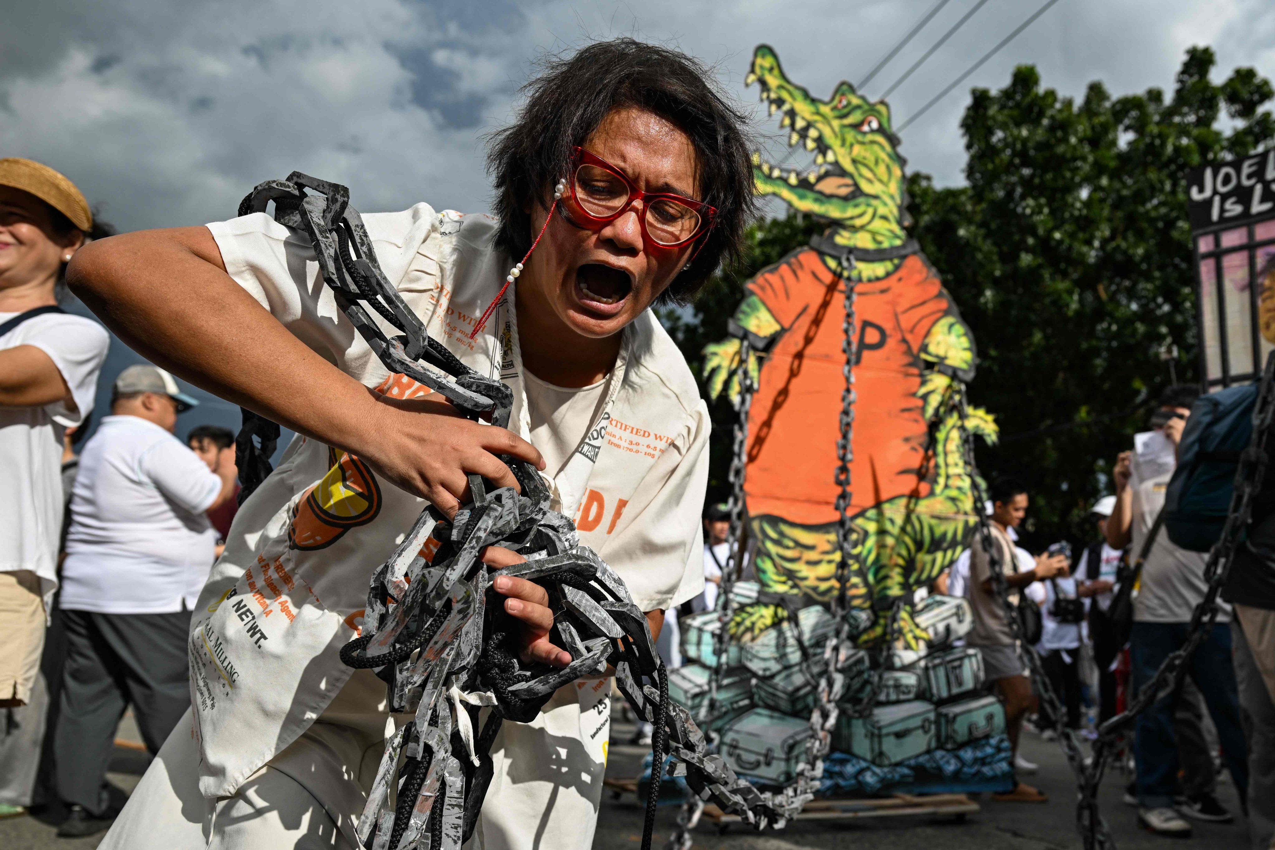 A protester holds a chain linked to an effigy of a crocodile, which represents corrupt officials, during anti-corruption rally along Epifanio de los Santos Avenue, or EDSA, in Quezon City on Sunday. Photo: AFP
